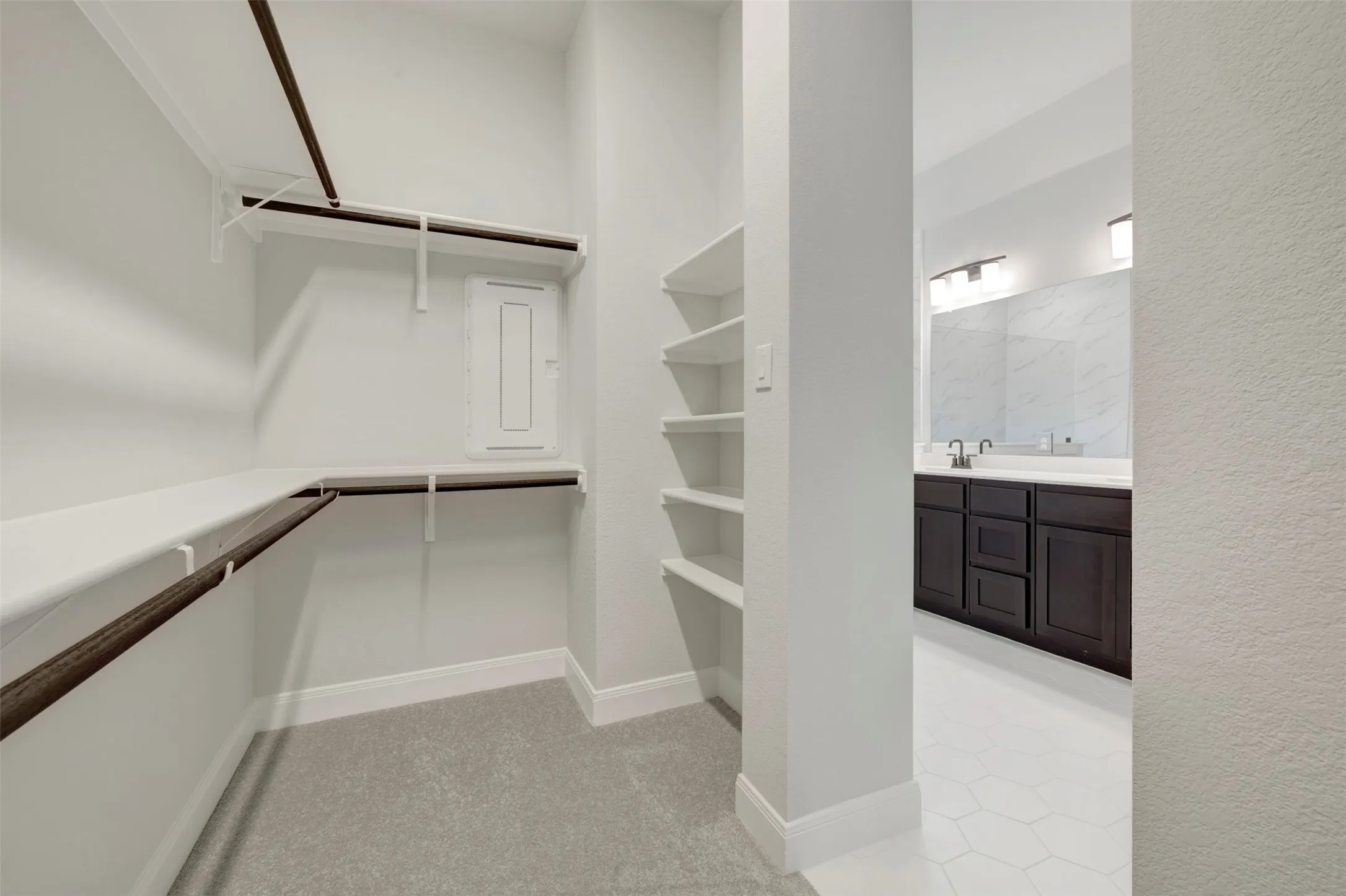 Walk in closet with light colored carpet