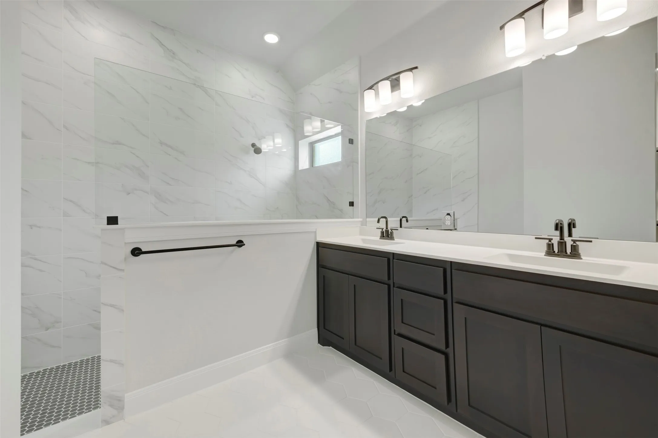 Bathroom featuring double vanity and a marble finish shower