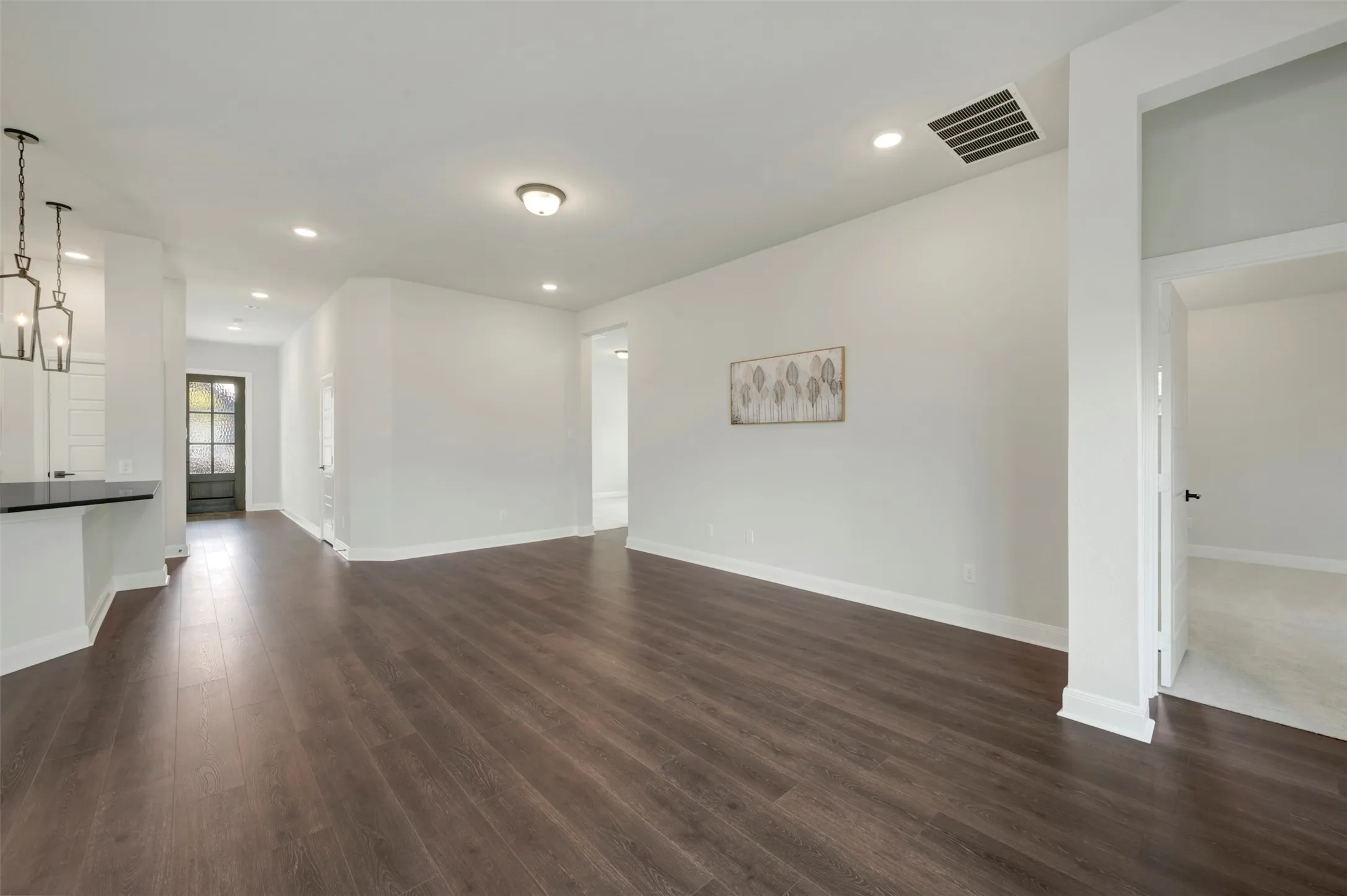 Unfurnished living room featuring dark wood-style floors and recessed lighting