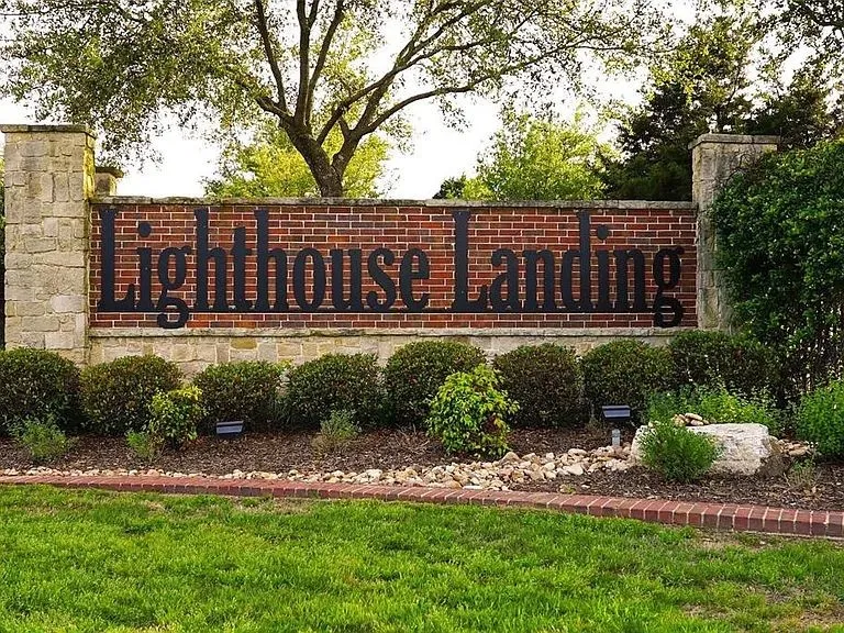 Community / neighborhood sign featuring a yard