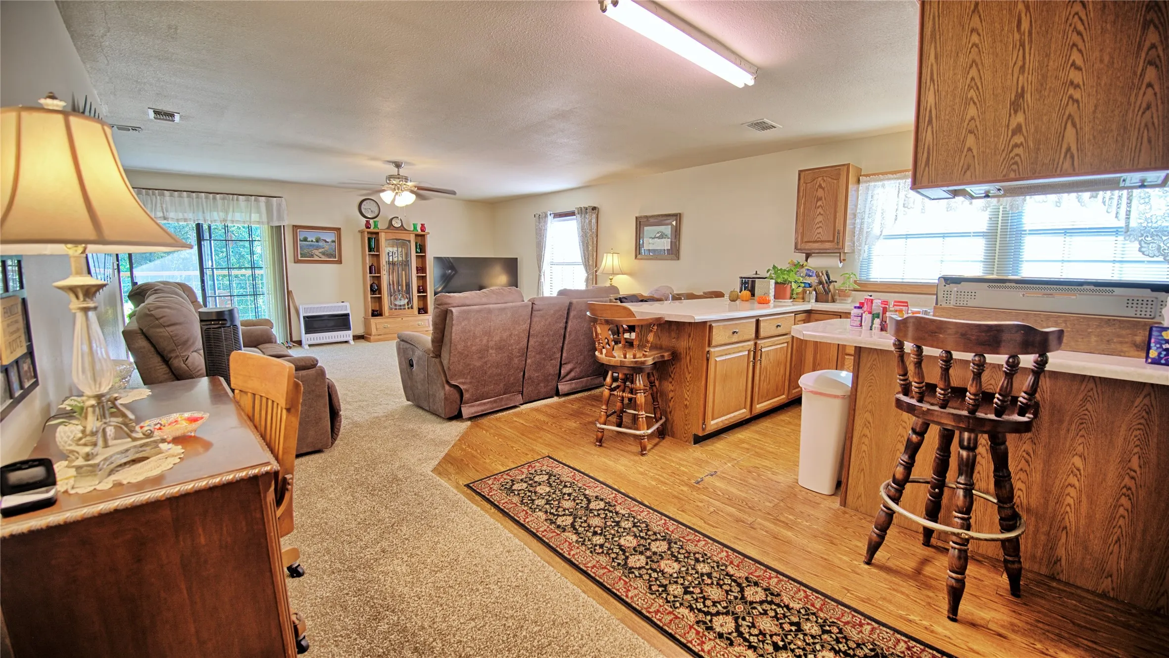 Kitchen featuring a kitchen breakfast bar, light countertops, healthy amount of natural light, open floor plan, and a textured ceiling