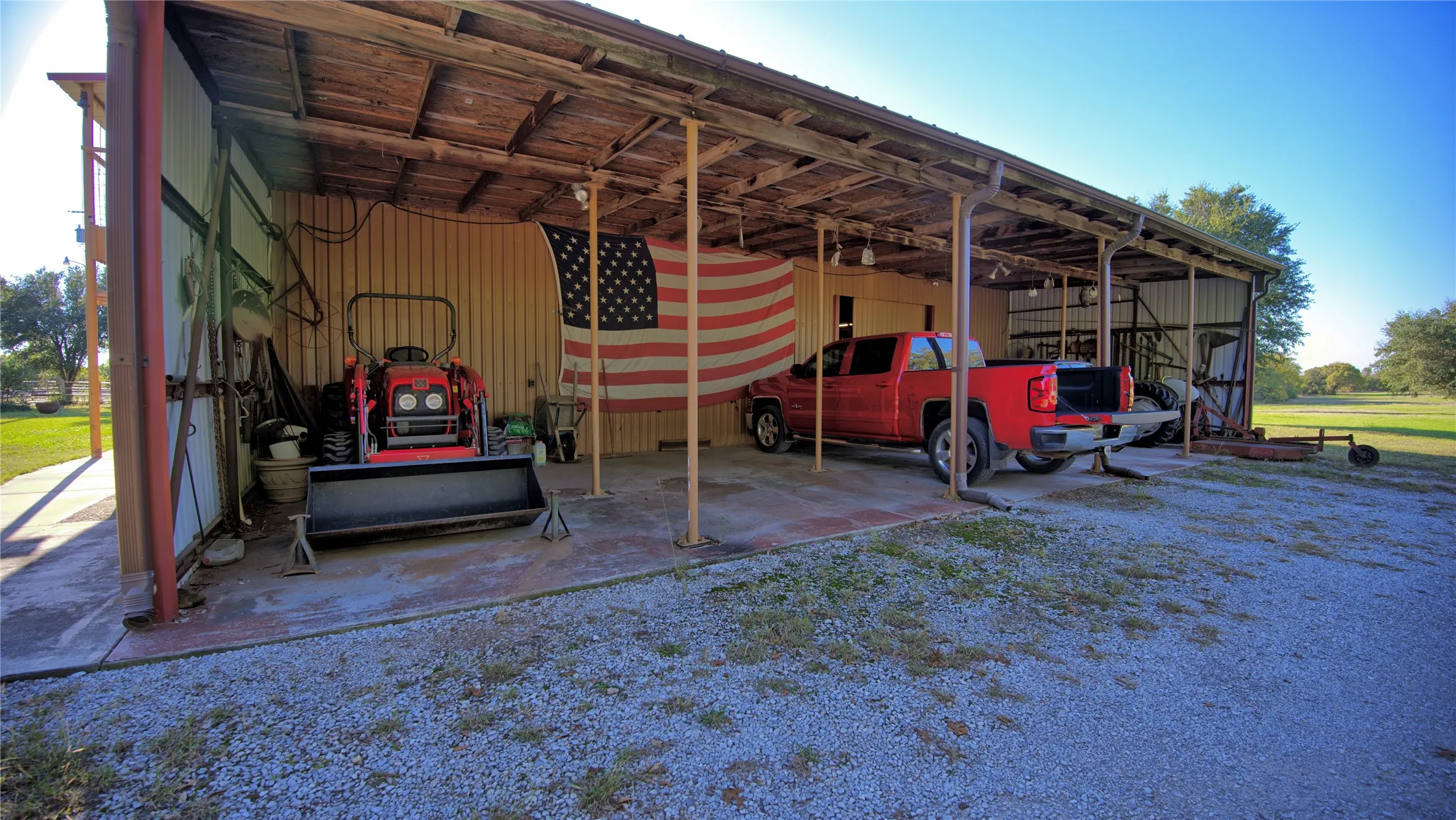 View of vehicle parking featuring an outbuilding and a carport