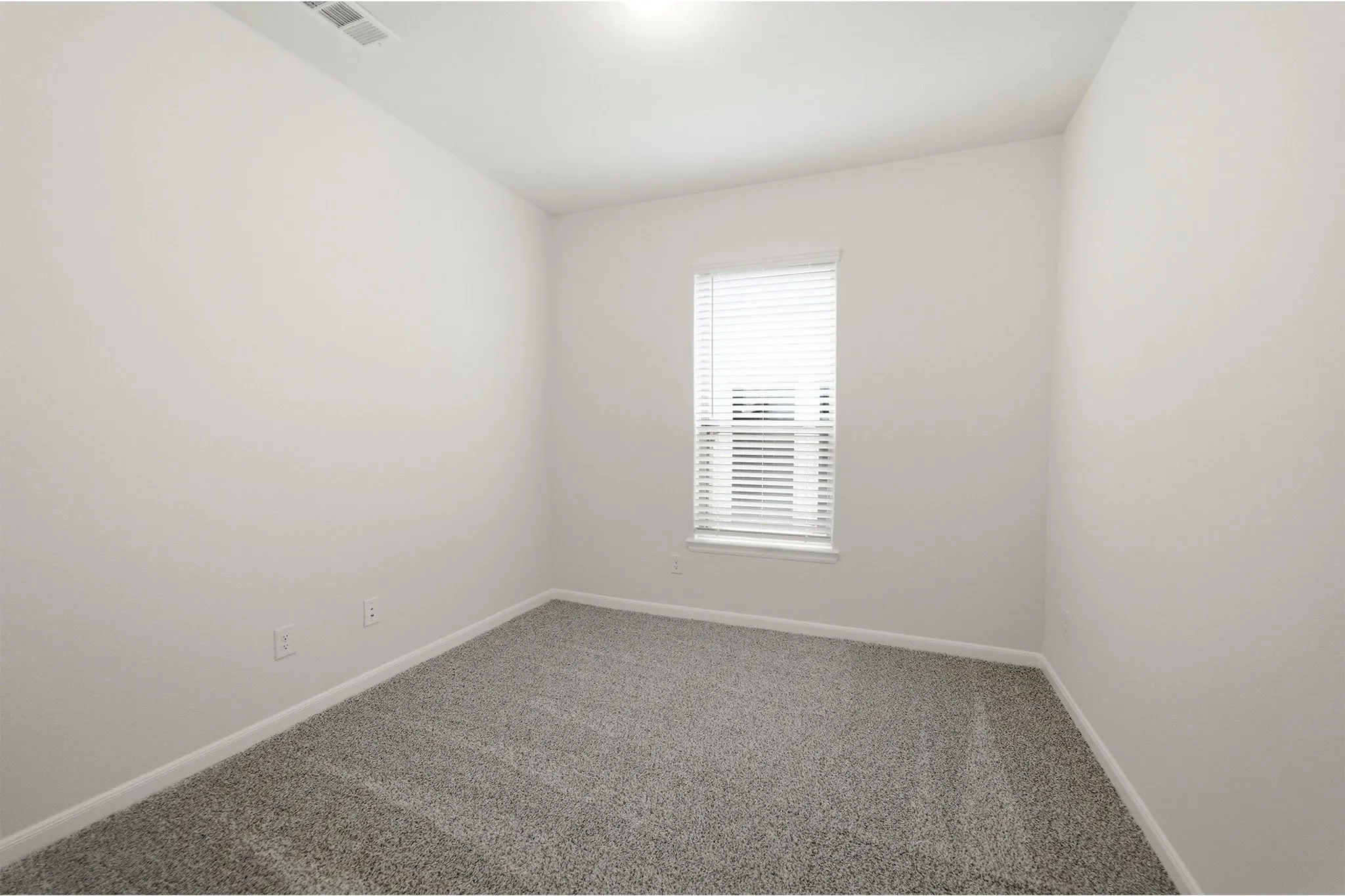 Bright room with neutral wall paint, gray carpet flooring, white trim, and a window with horizontal blinds