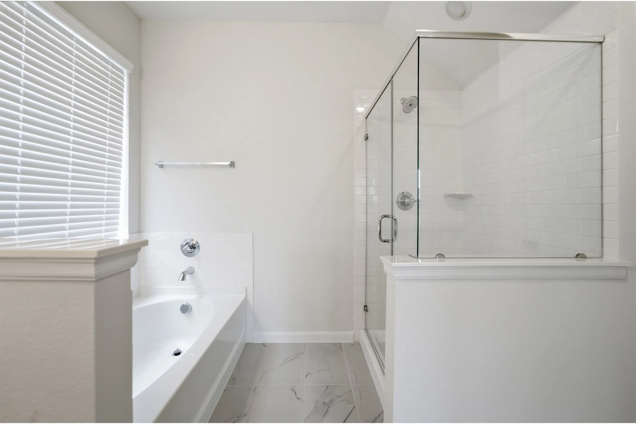 Contemporary bathroom featuring a spacious walk-in shower with clear glass enclosure, a white subway tile surround, and a built-in tub with chrome fixtures