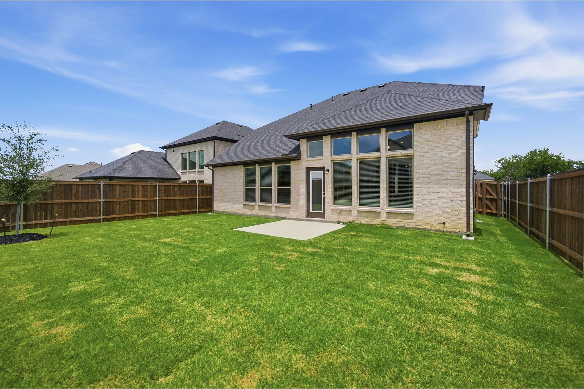 Expansive green lawn with a concrete patio
