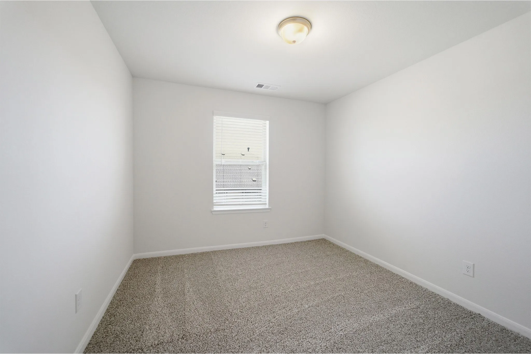 Room featuring neutral-toned carpet flooring, white painted walls, and a single window with horizontal blinds