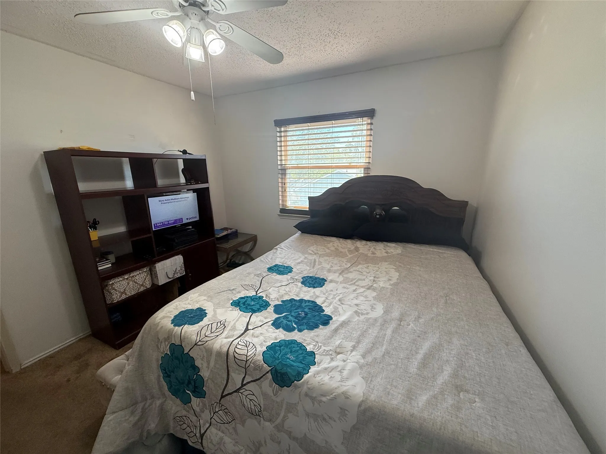 Bedroom featuring a textured ceiling, carpet flooring, and ceiling fan