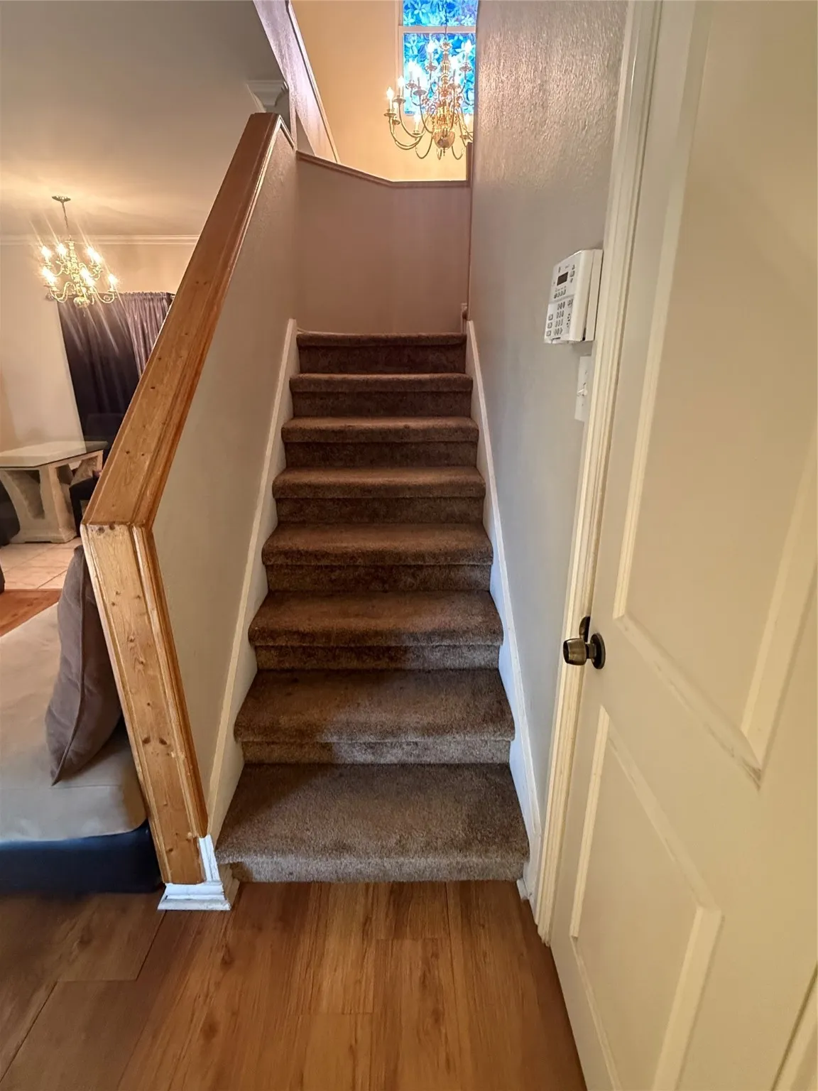 Staircase with a chandelier and wood finished floors