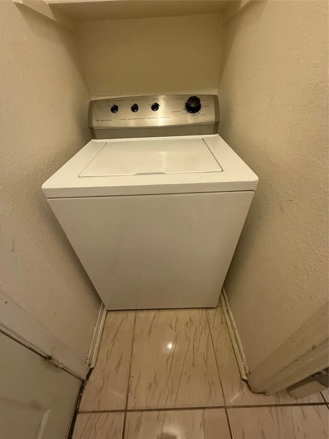 Laundry room with a textured wall, washer / clothes dryer, and marble finish floors
