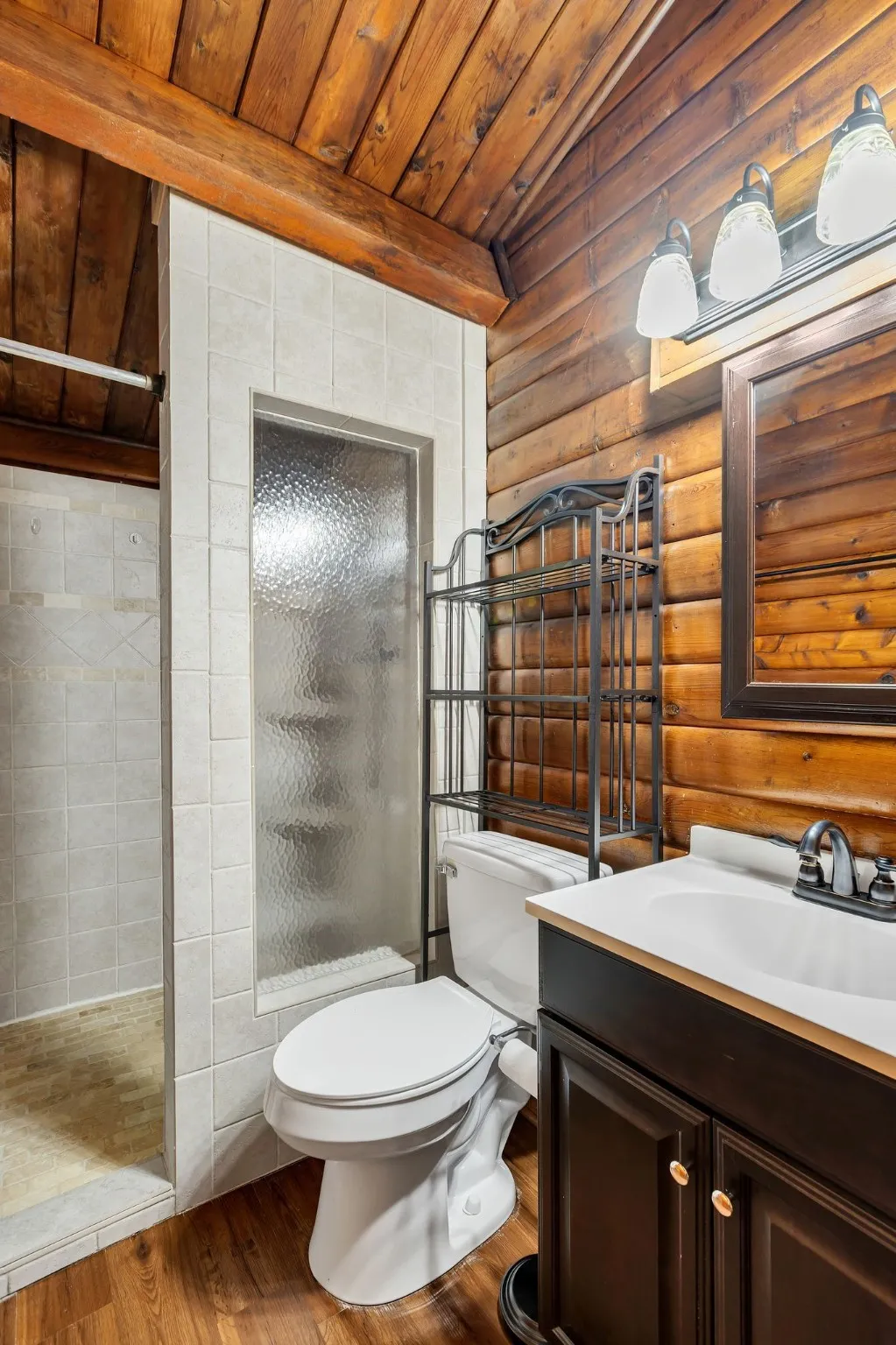 Bathroom featuring a shower stall, vanity, wood finished floors, lofted ceiling, and wooden ceiling