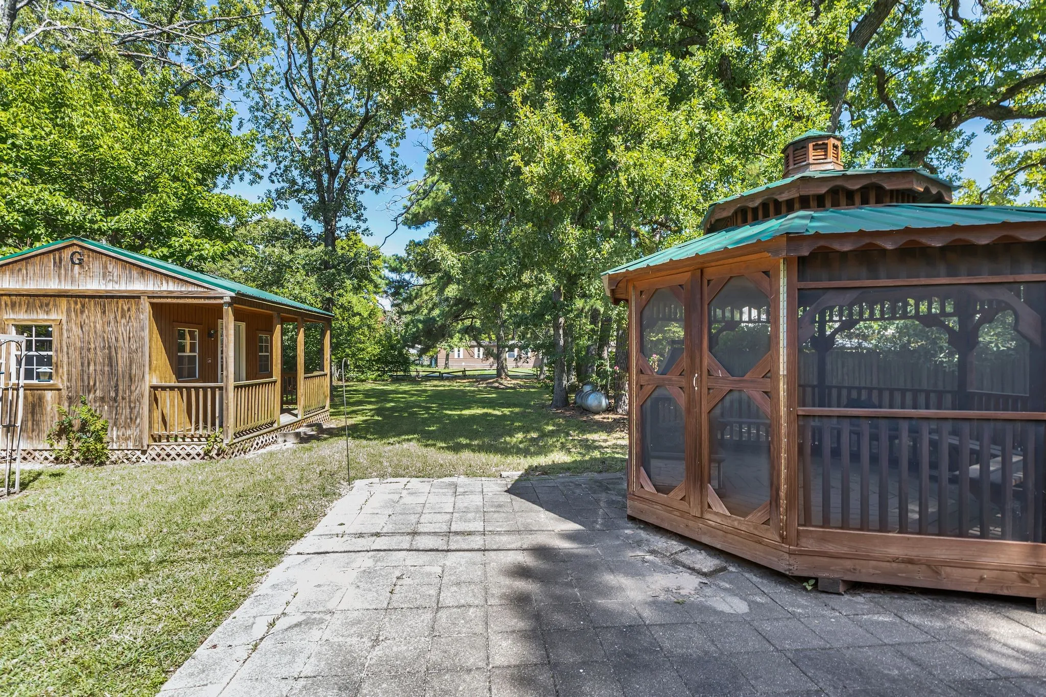 Backyard with gazebo, outdoor gas fireplace, outbuilding wired for electric