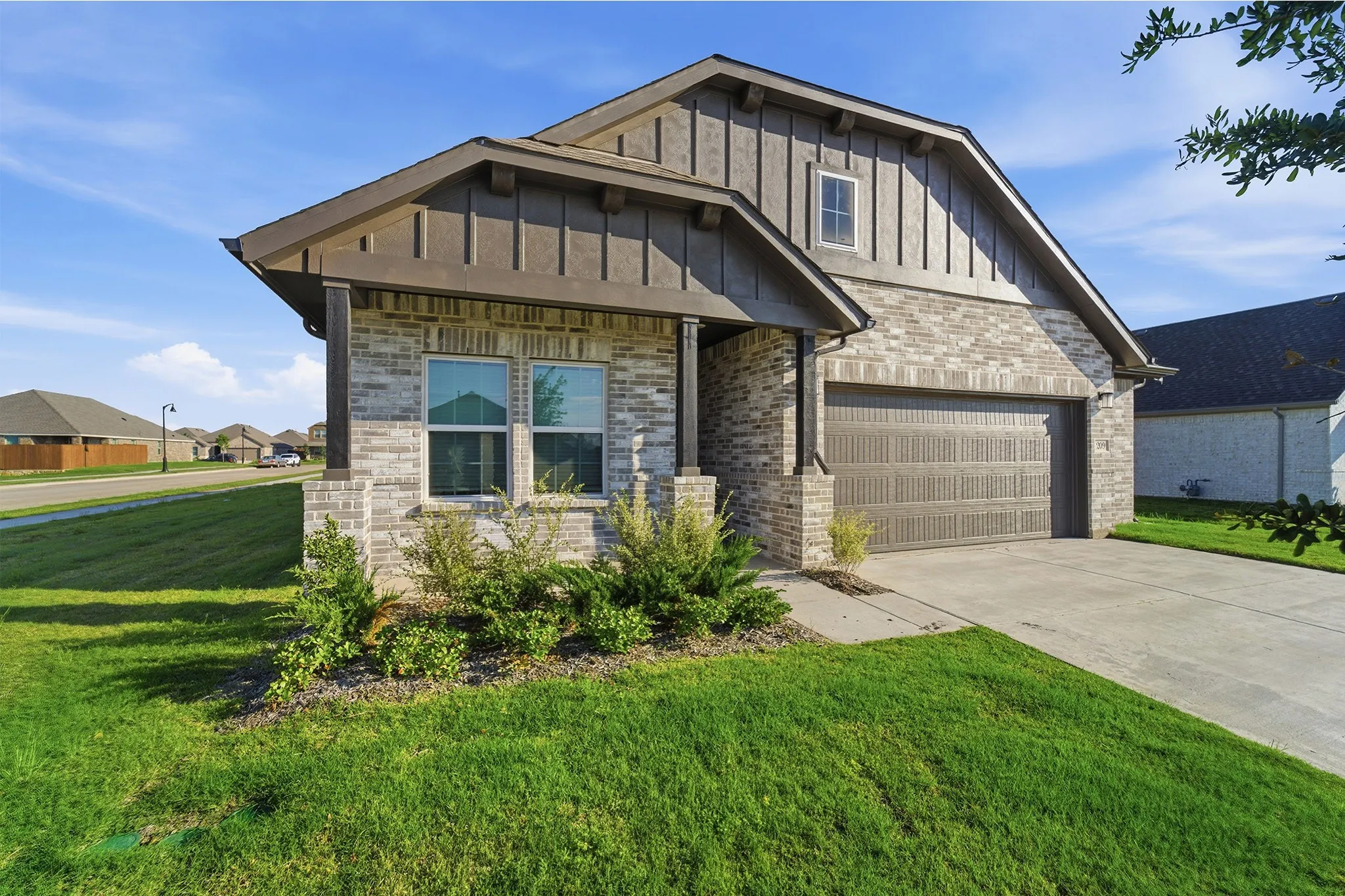 Contemporary exterior featuring light grey brick and vertical wood-look siding accents
