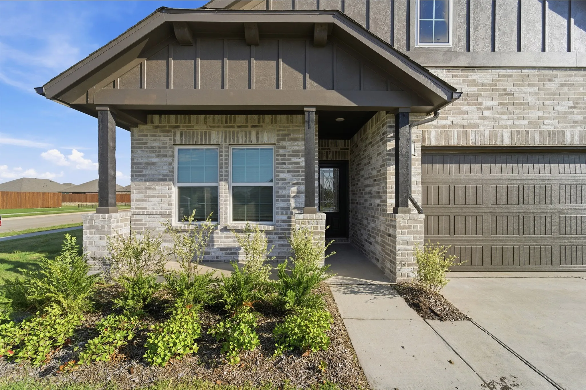 Front elevation featuring light-colored brick with dark trim accents