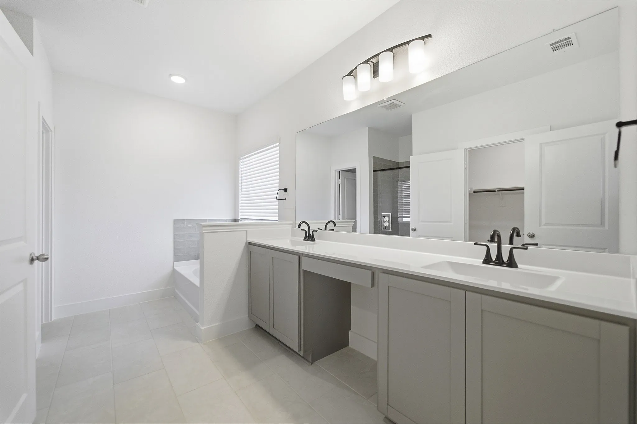 Dual vanity with light gray cabinetry, white countertops, and matte black fixtures