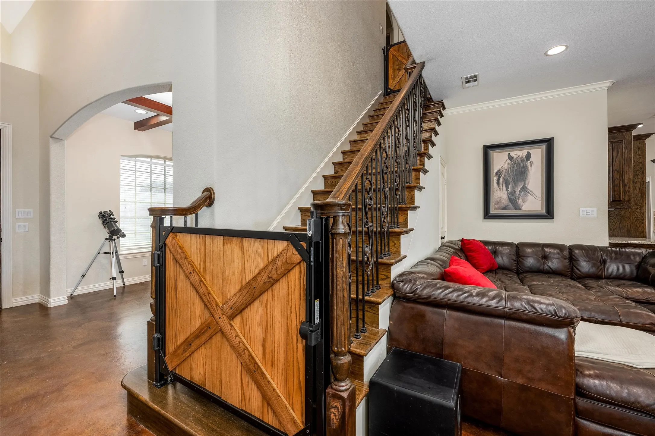 Stairway featuring custom rustic baby/dog gate, concrete flooring, arched walkways, and recessed lighting