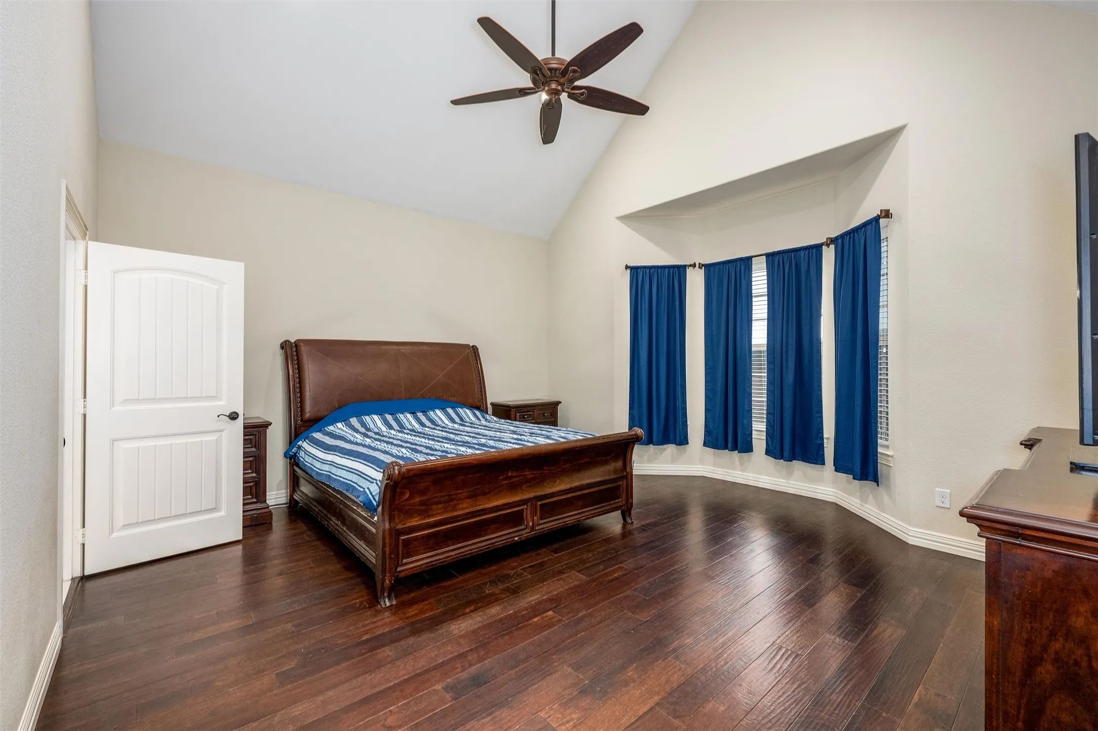 Master Bedroom with high vaulted ceiling, a ceiling fan, and dark wood floors