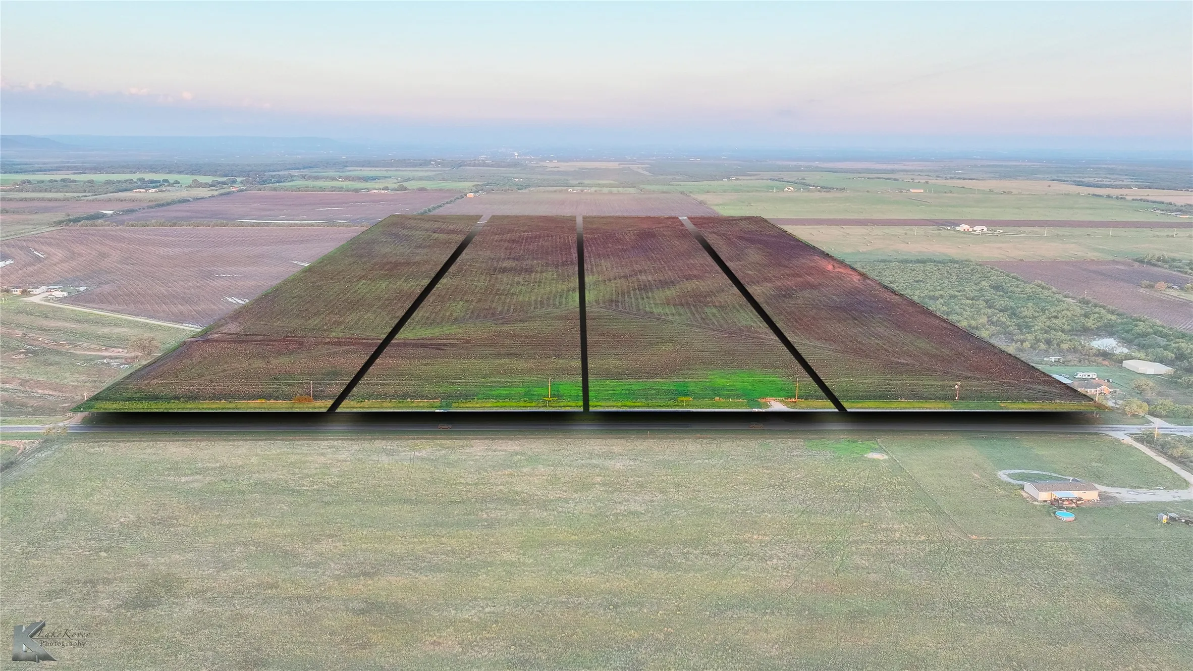 Aerial view of sparsely populated area featuring large plots for crops