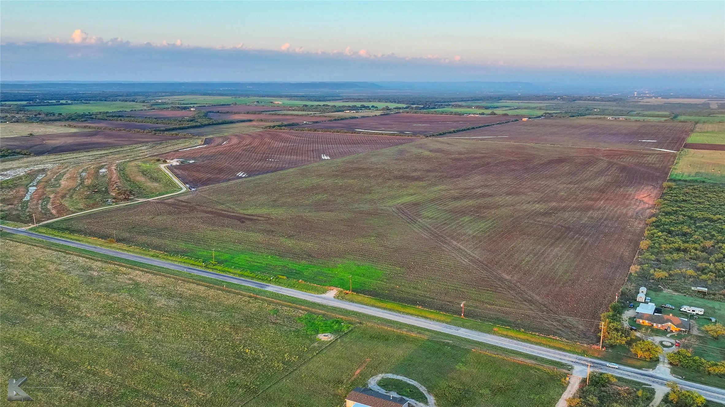 Aerial view of property's location with rural landscape and rows of crops