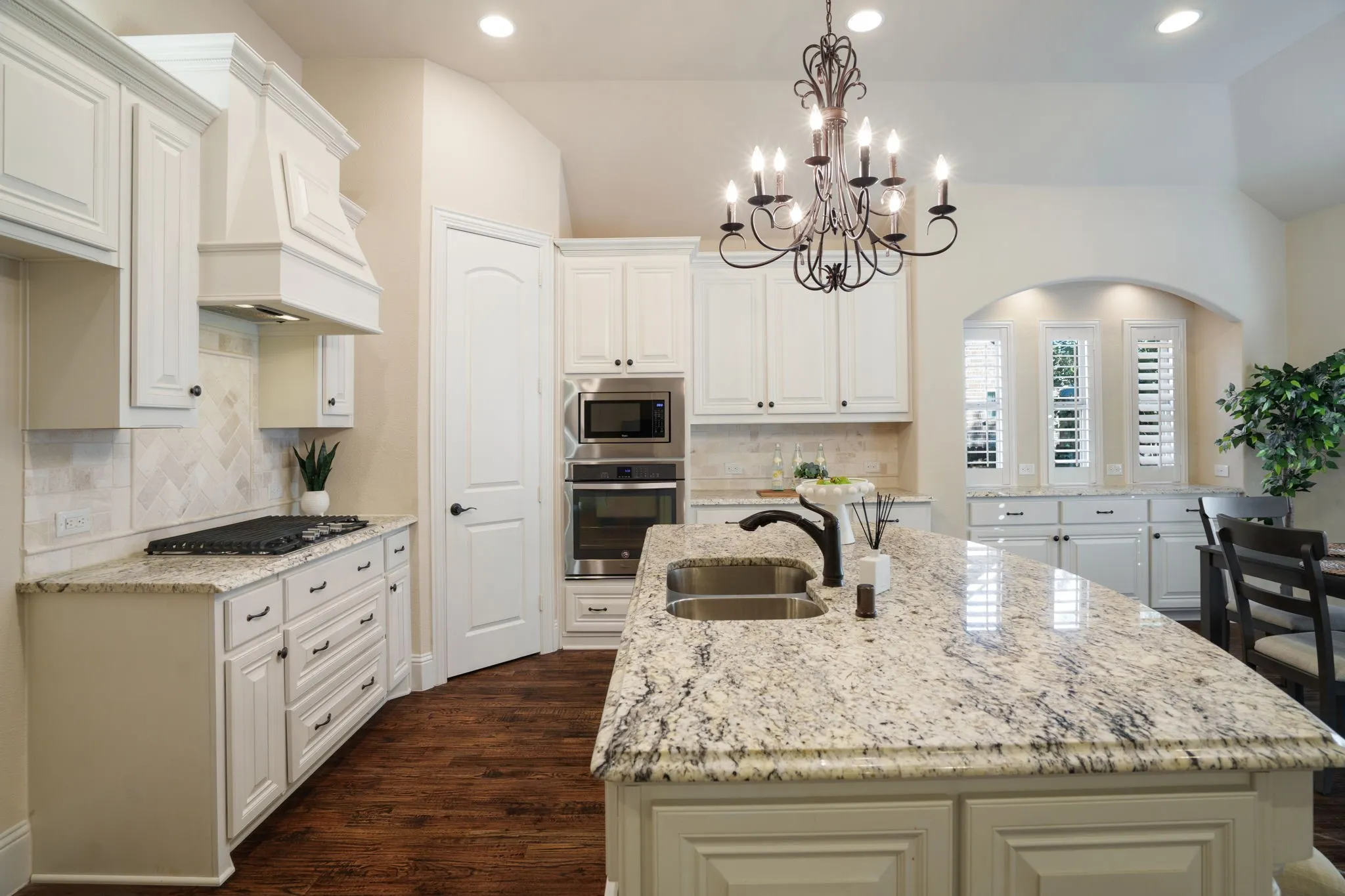 Chef’s kitchen featuring a large island, gas cooktop, built-in microwave/oven combo, and custom cabinetry.