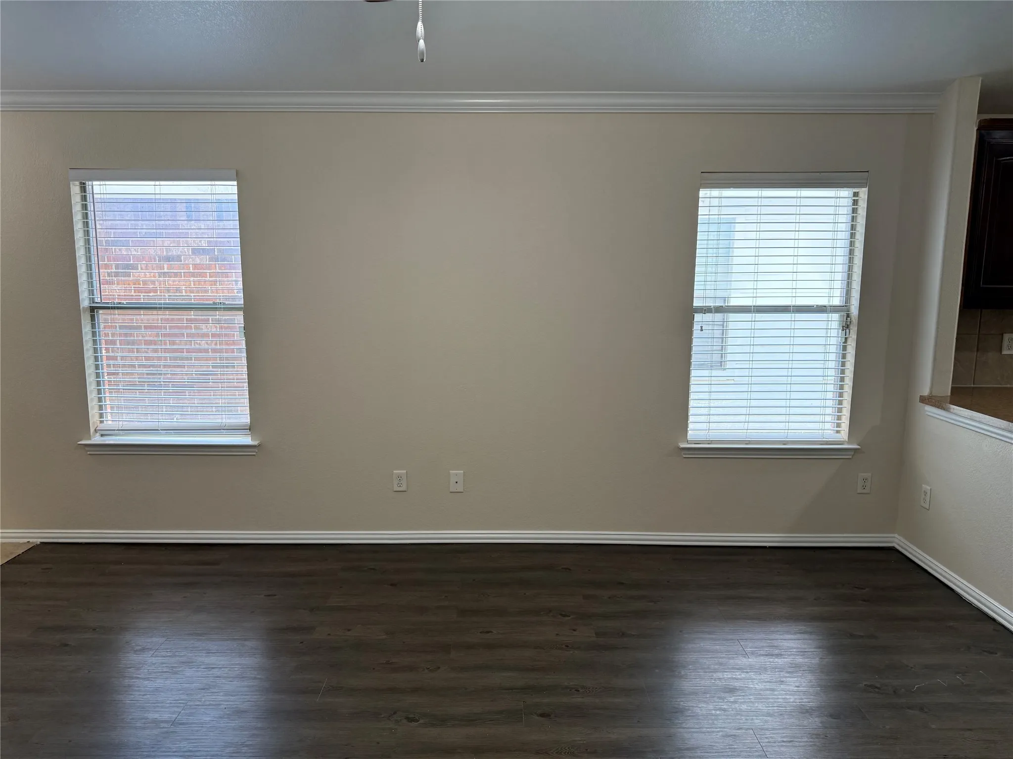 Unfurnished room featuring ornamental molding and dark wood finished floors