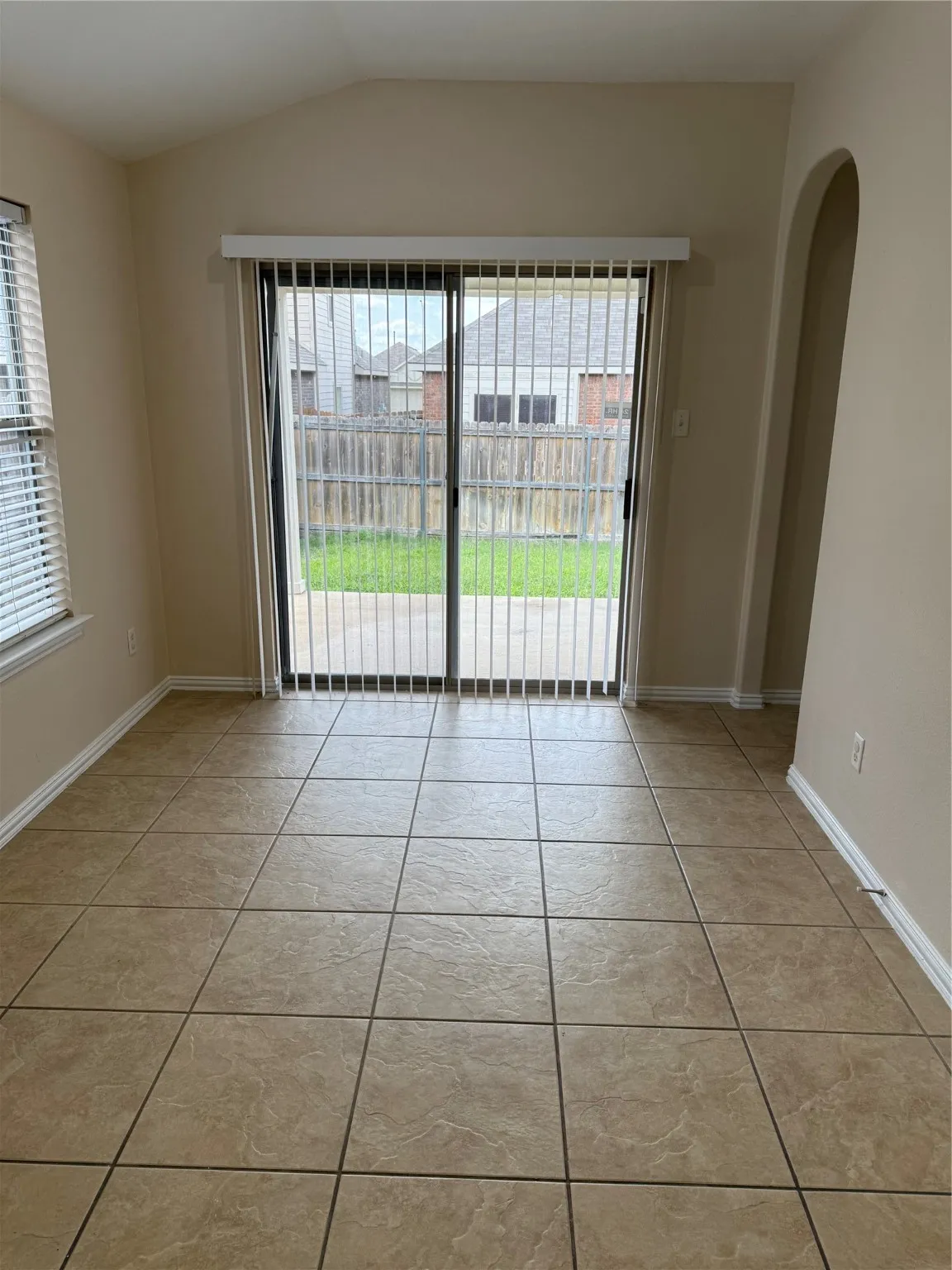 Spare room featuring arched walkways and lofted ceiling