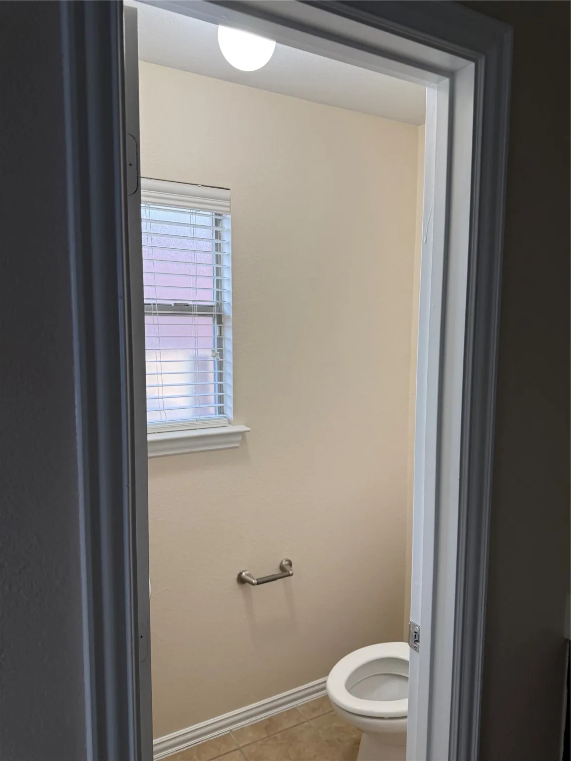 Bathroom with toilet and light tile patterned floors