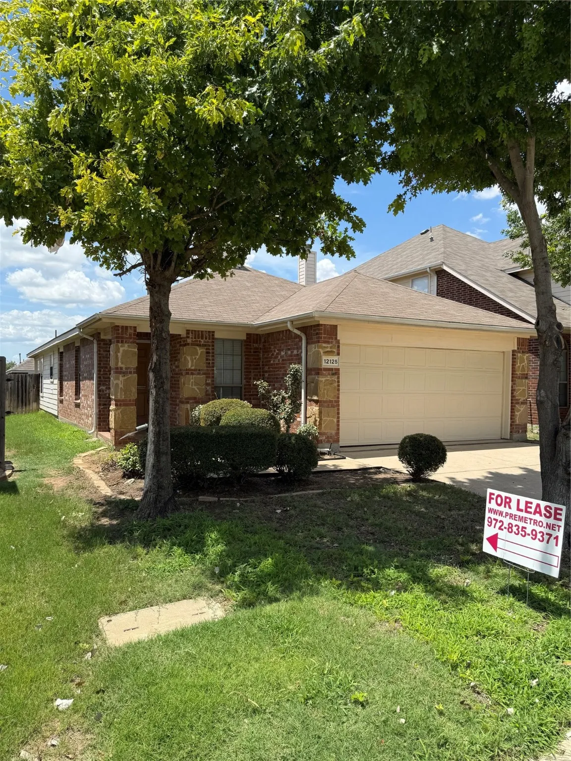 Ranch-style house featuring brick siding, a garage, concrete driveway, a front yard, and a chimney