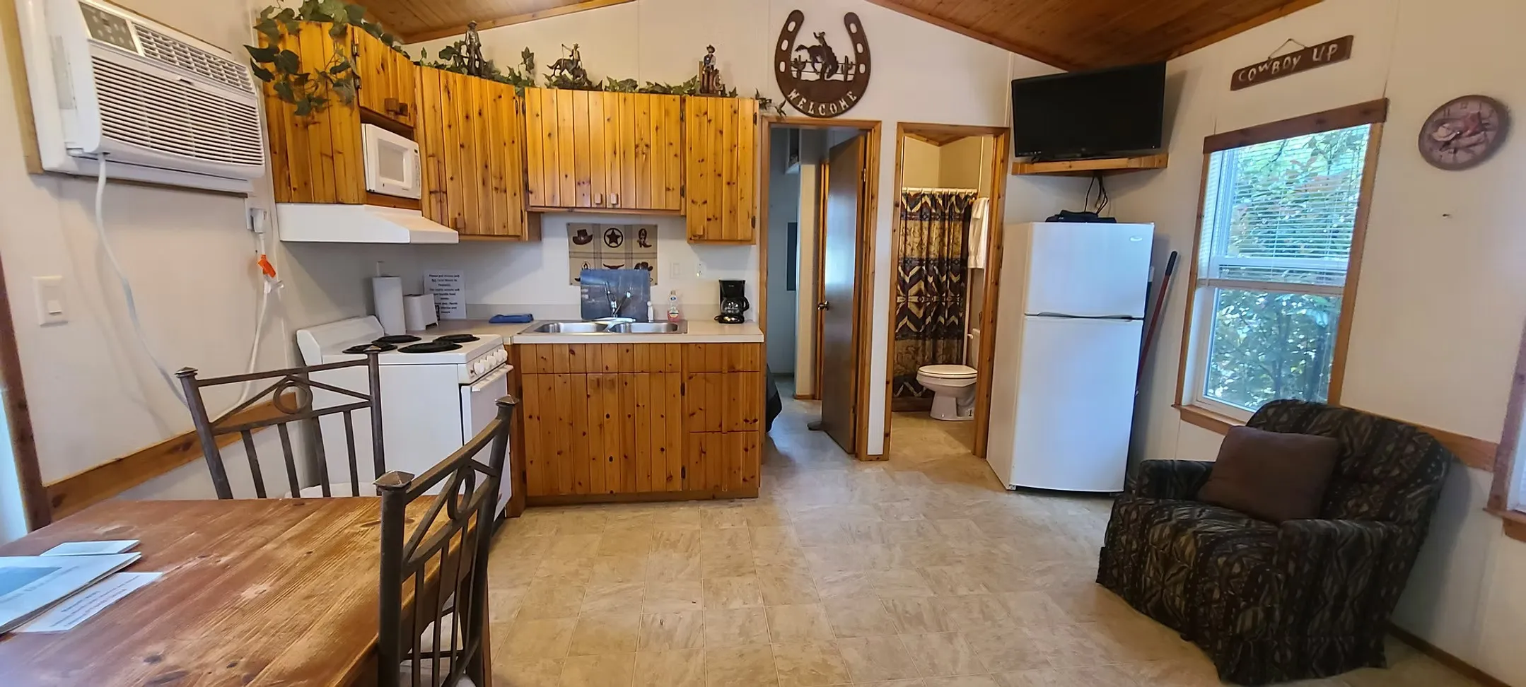 Kitchen featuring light countertops, lofted ceiling, white appliances, wood ceiling, and under cabinet range hood