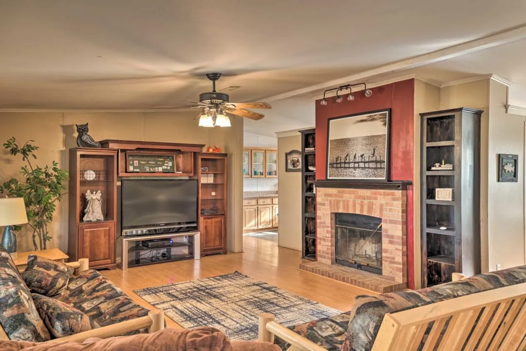 Living area featuring ornamental molding, light wood-style floors, a fireplace, and ceiling fan