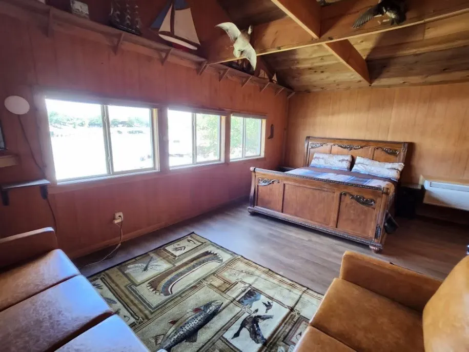 Bedroom featuring wood walls, lofted ceiling, light wood-style flooring, and wood ceiling