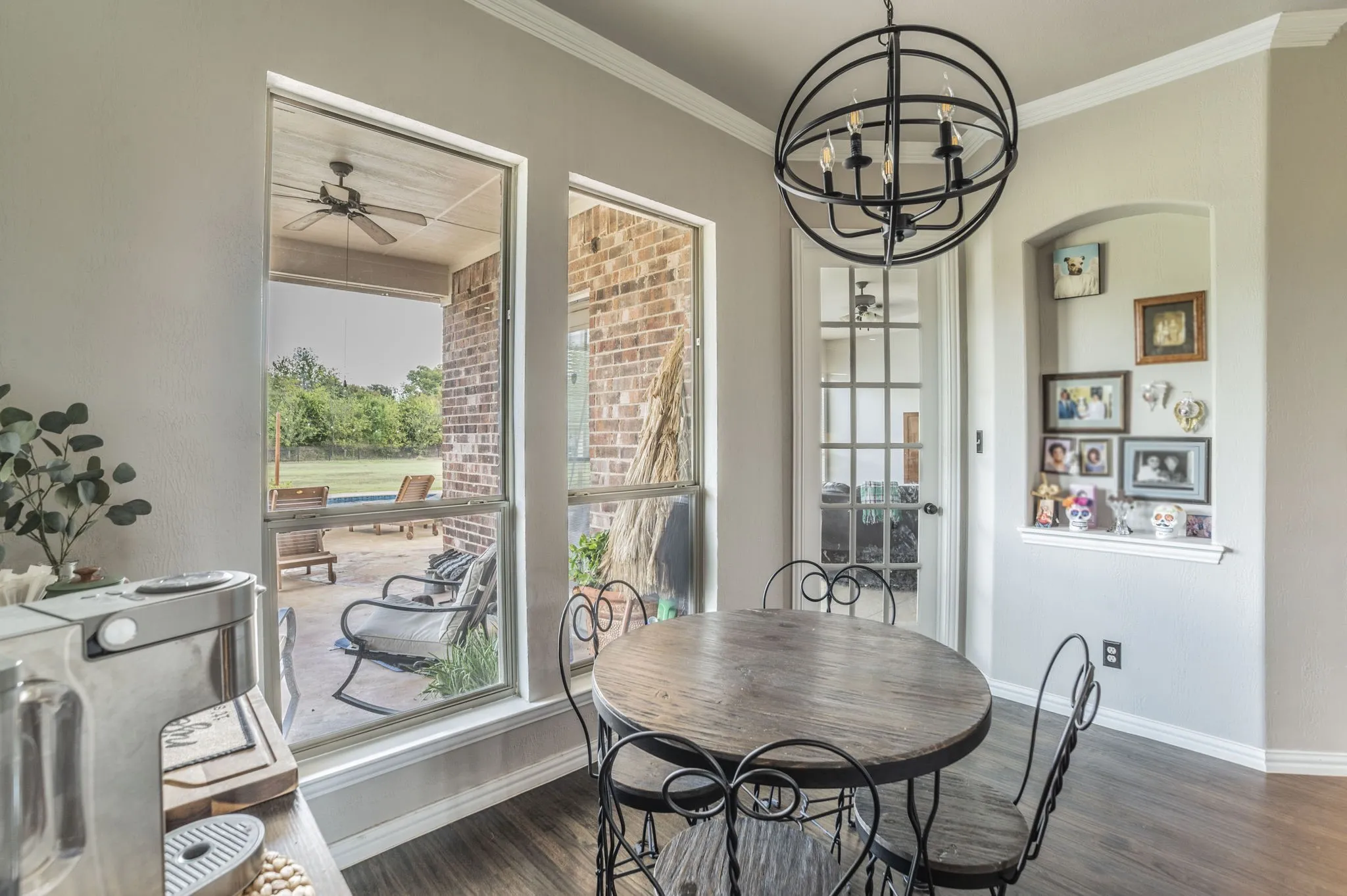 Dining space featuring plenty of natural light, dark wood finished floors, a ceiling fan, crown molding, and a chandelier
