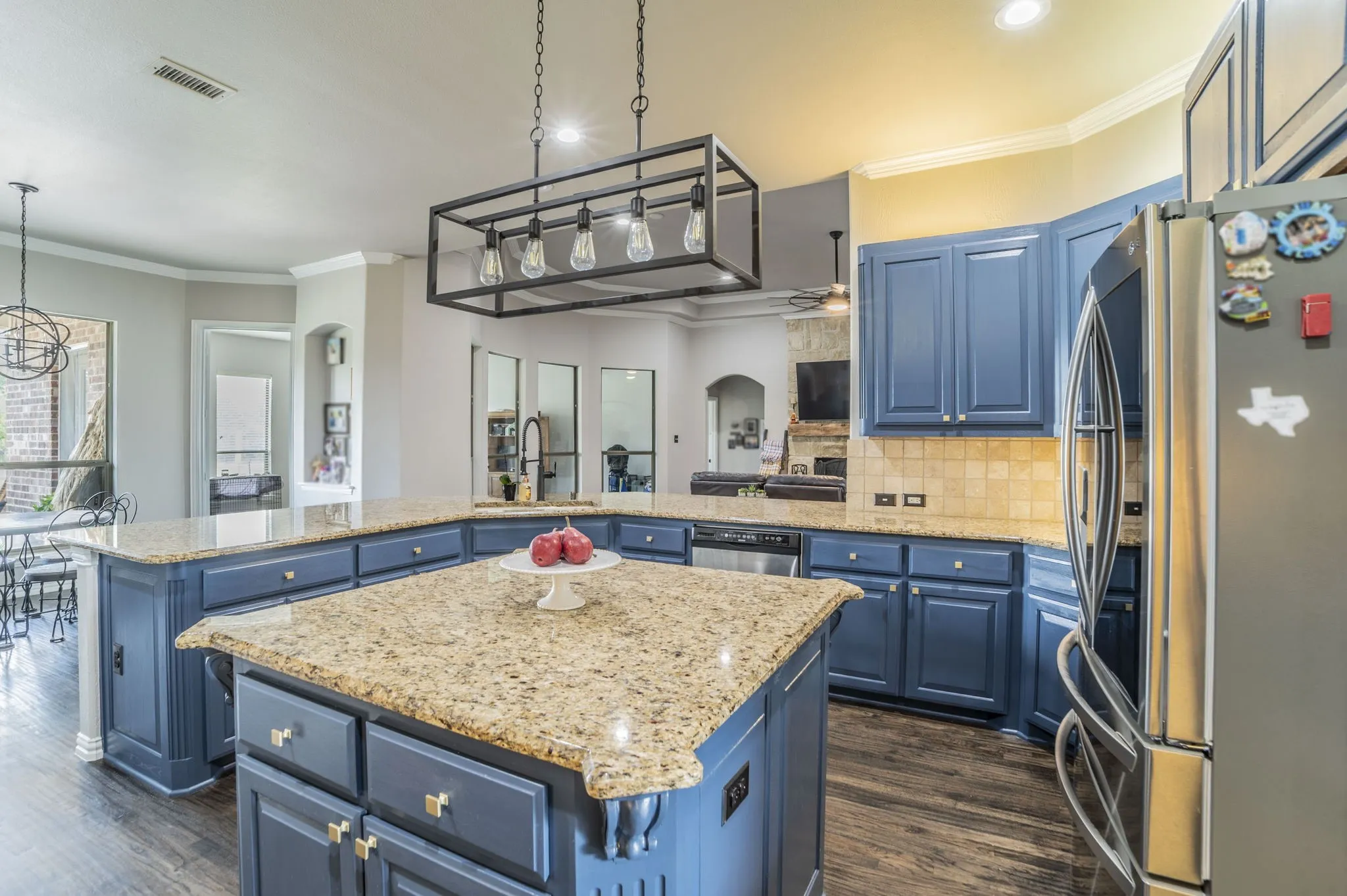 Kitchen featuring ornamental molding, blue cabinetry, stainless steel appliances, backsplash, and light stone countertops
