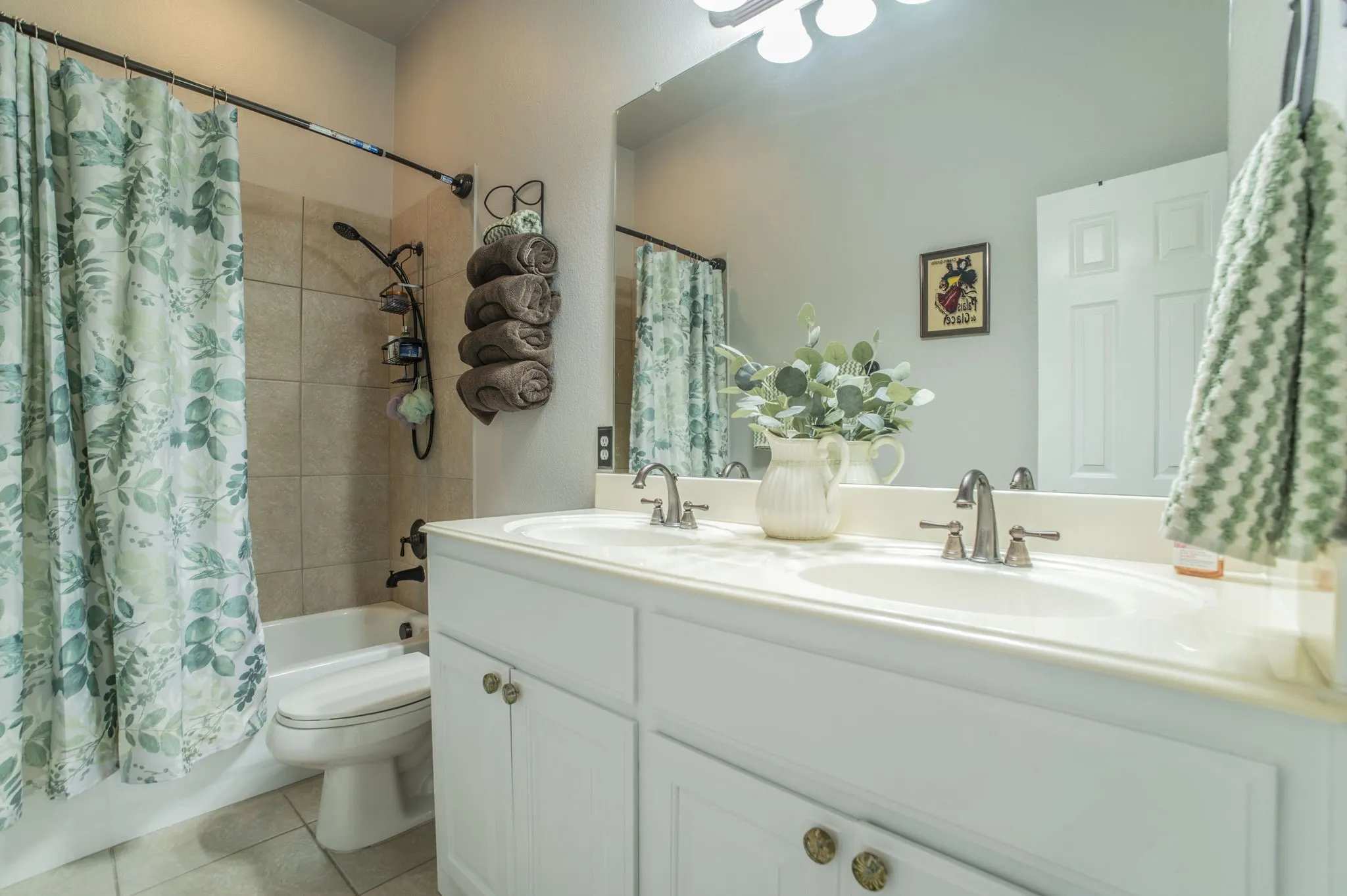 Full bathroom featuring shower / bath combo, double vanity, and light tile patterned floors
