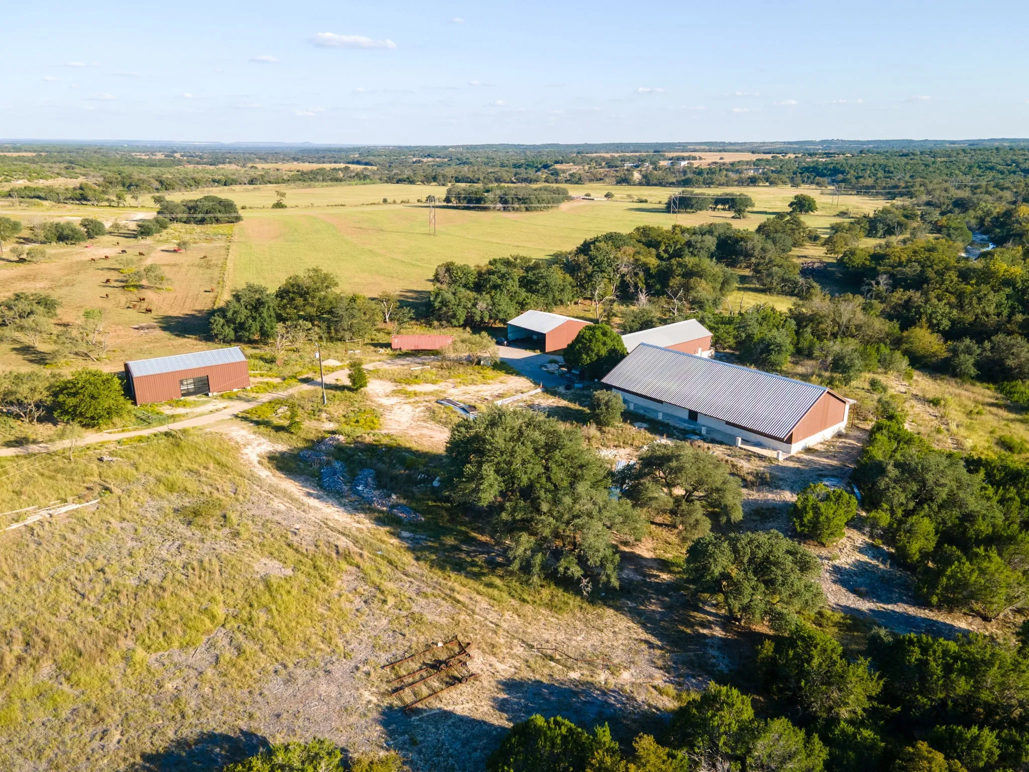 Expansive rural property featuring multiple structures with metal roofs