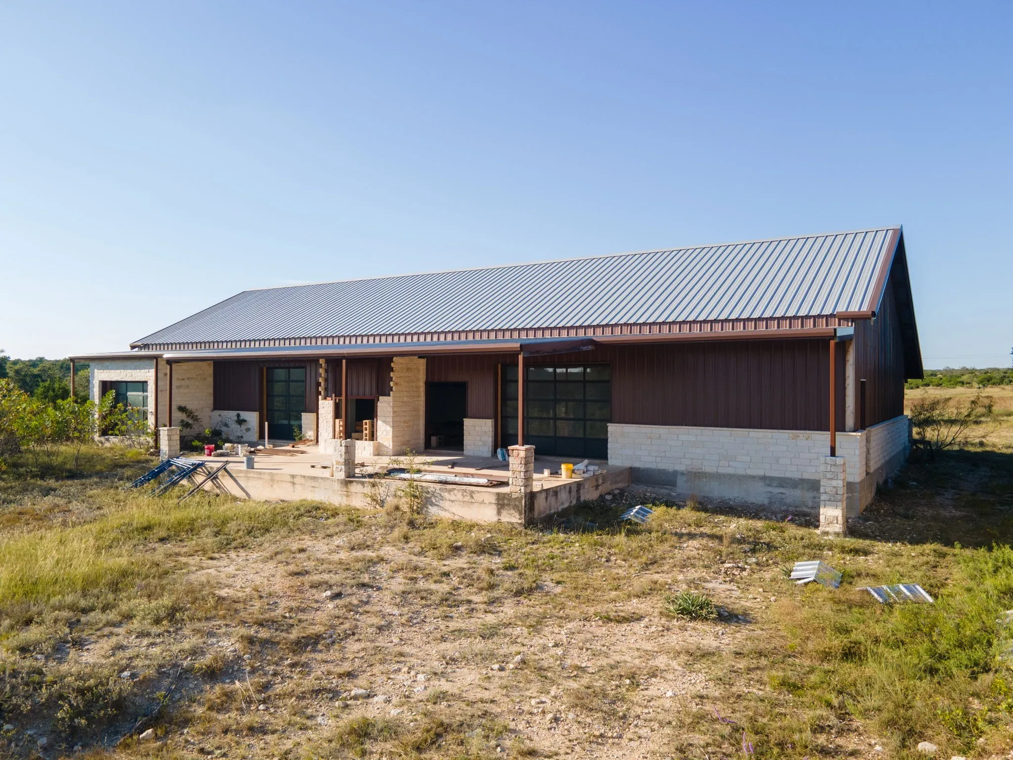 Contemporary structure featuring a metal roof, brown siding, and stone accents