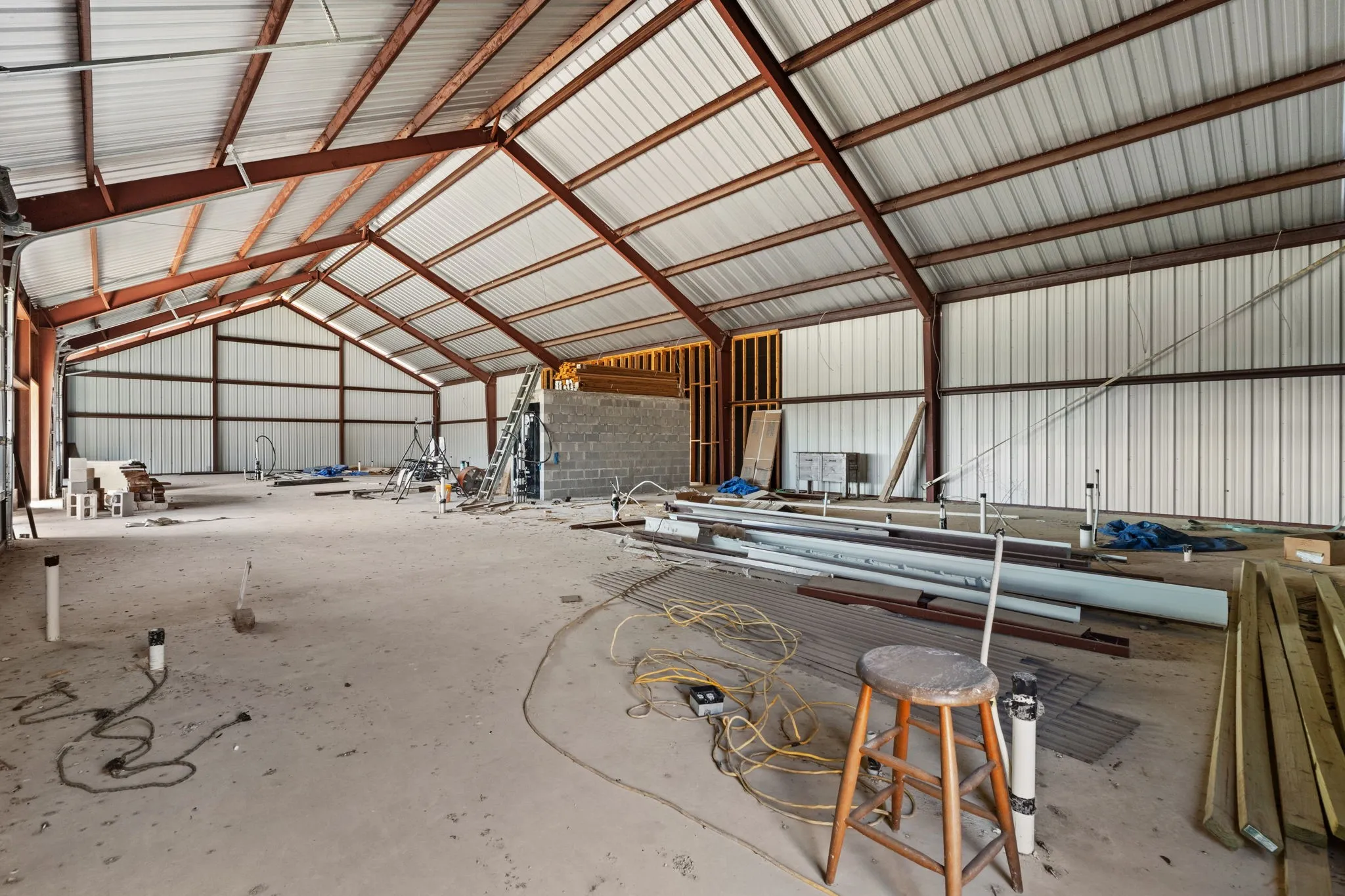 Expansive interior space featuring a high-pitched metal roof structure supported by exposed steel beams