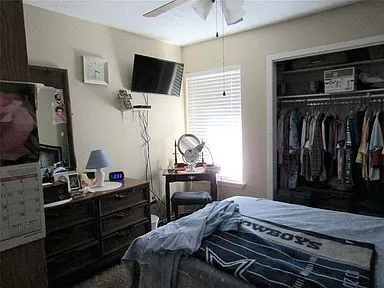 Carpeted bedroom featuring a closet and a ceiling fan