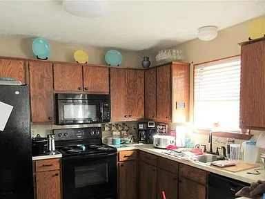 Kitchen with black appliances and light countertops