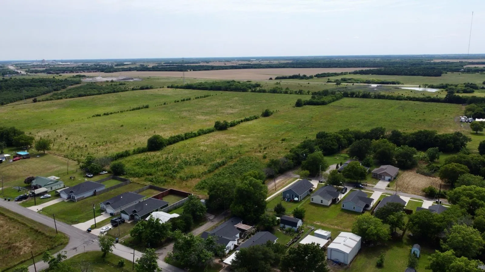 Aerial view of property and surrounding area featuring nearby suburban area