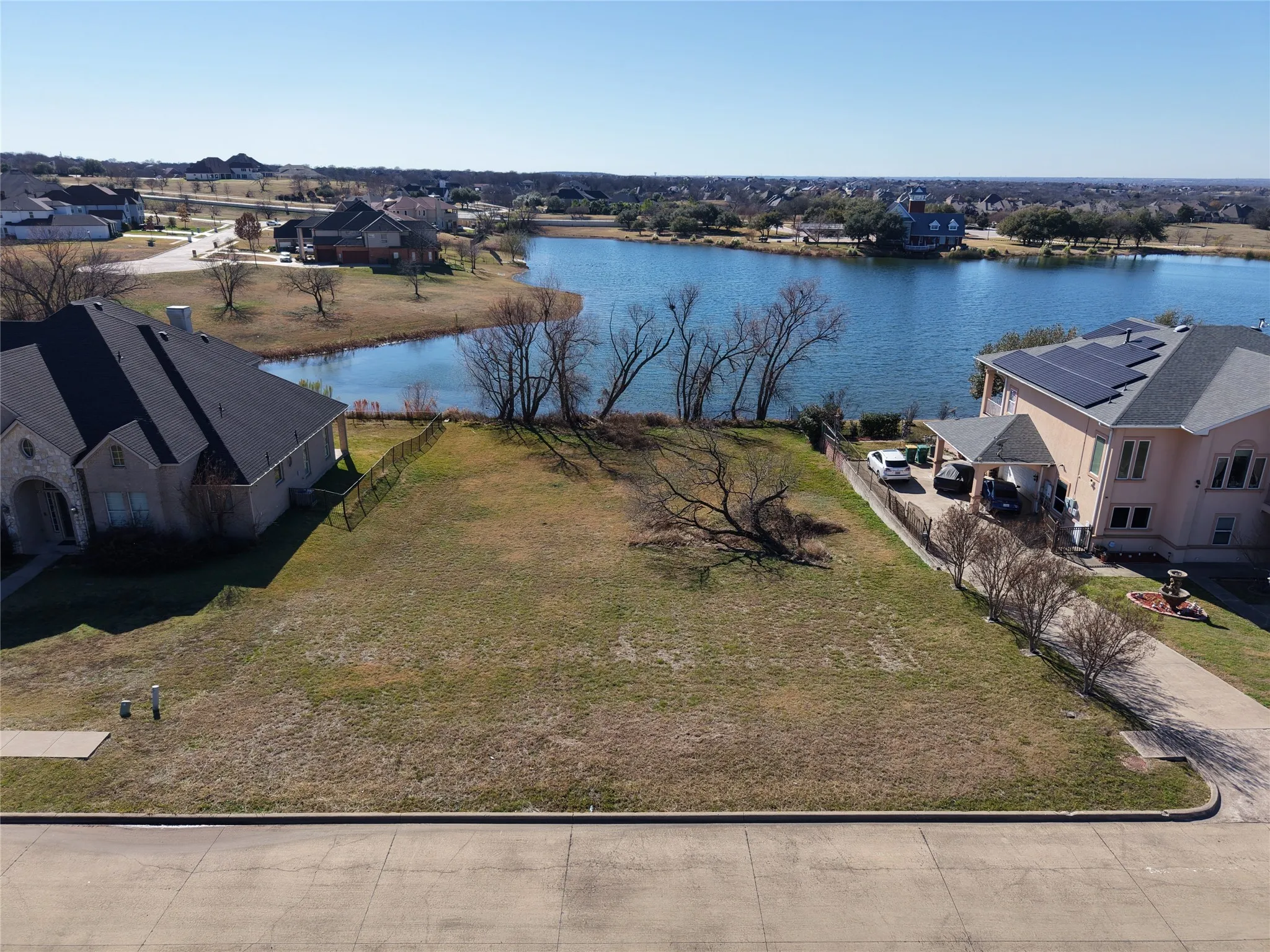 Aerial view of residential area featuring a nearby body of water