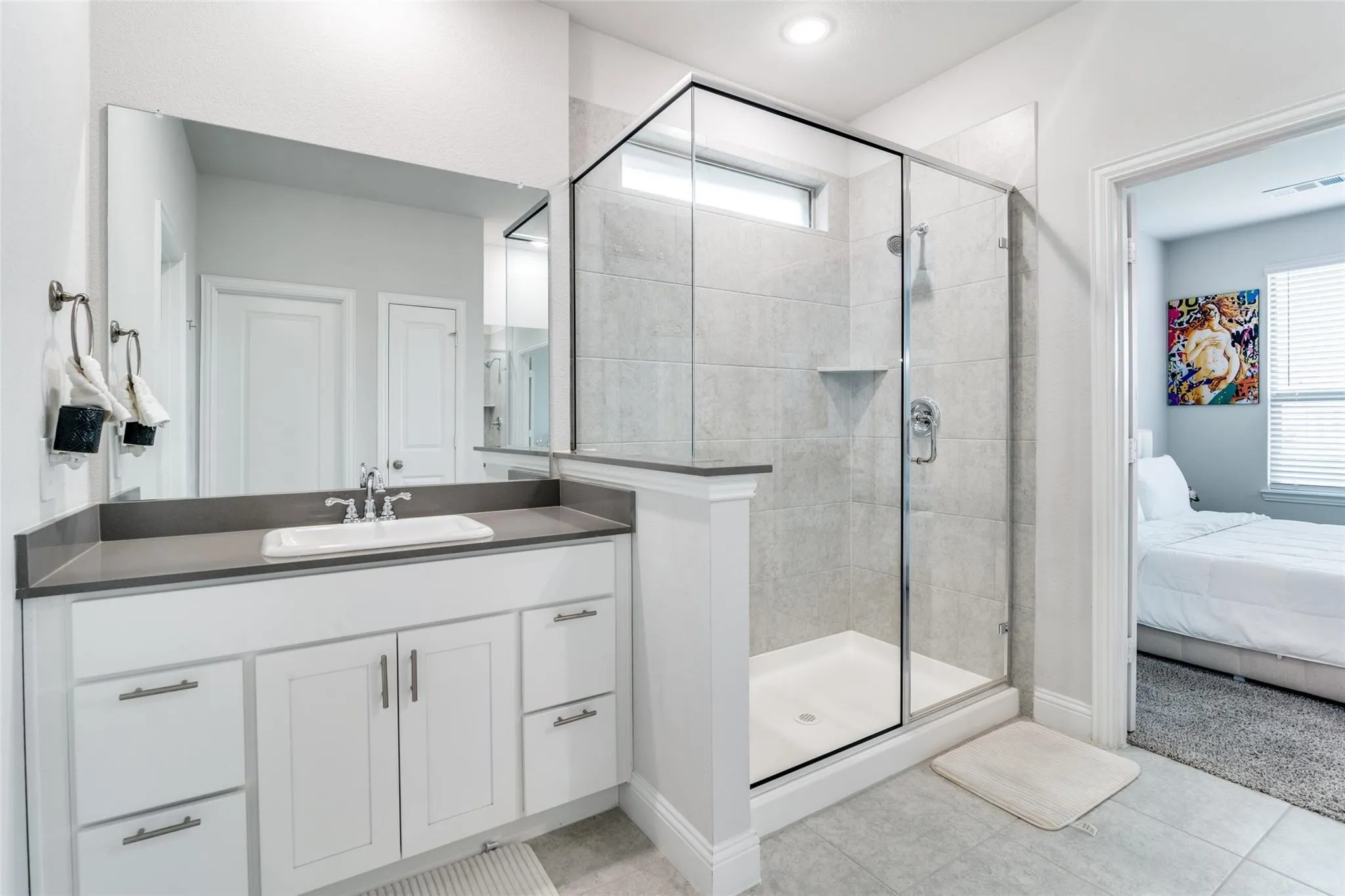 Bathroom with a stall shower, connected bathroom, vanity, and light tile patterned floors