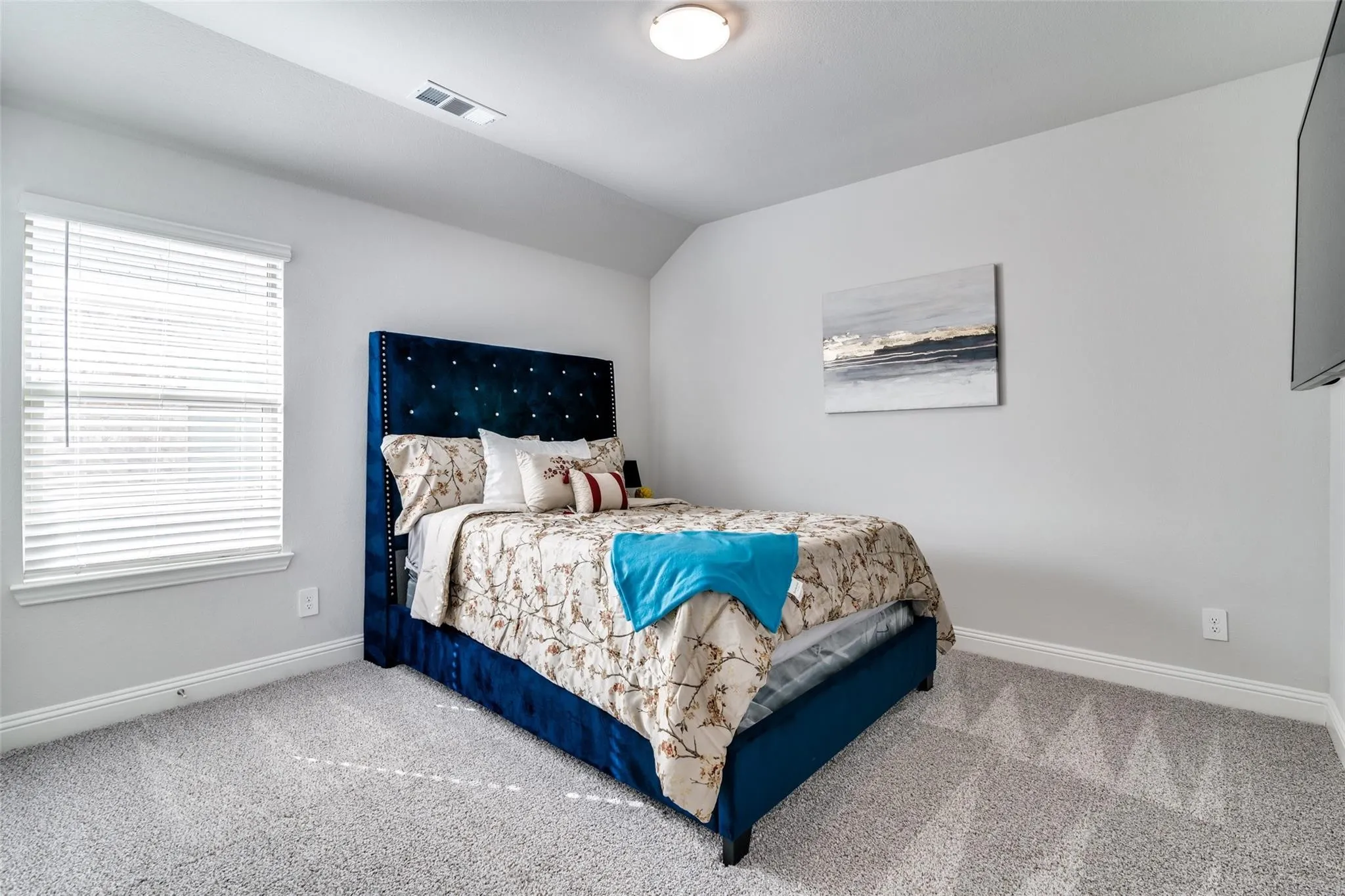 Carpeted bedroom with baseboards and vaulted ceiling