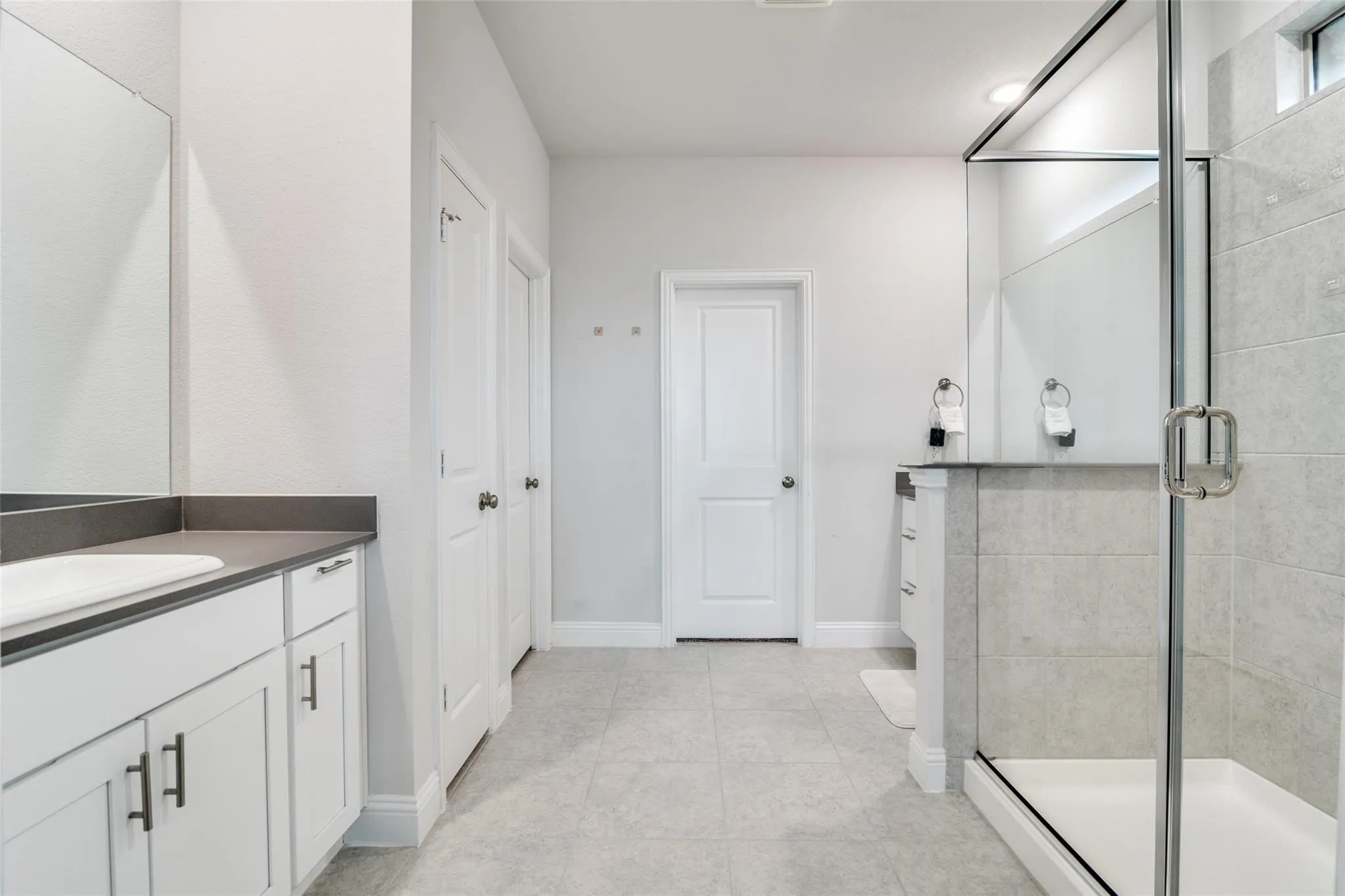 Bathroom with vanity, light tile patterned flooring, and a stall shower