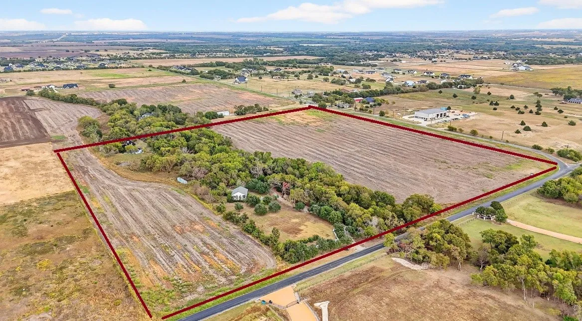 Expansive rural property featuring open fields and mature tree lines