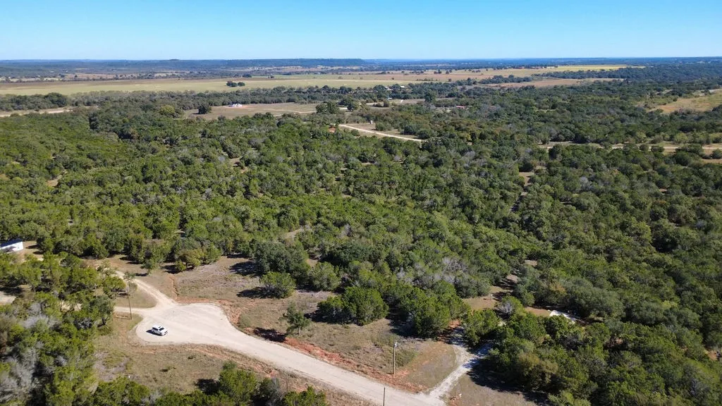 Aerial view of property's location featuring a heavily wooded area