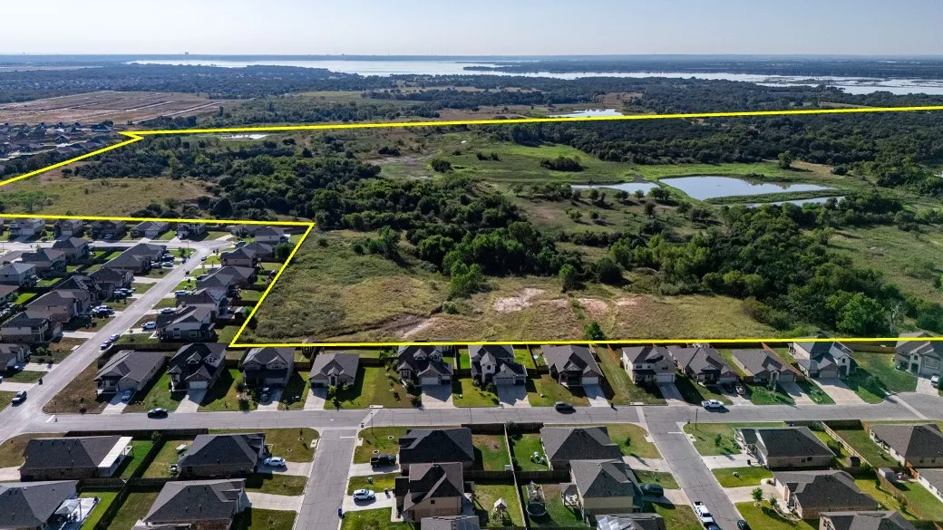 Aerial perspective of suburban area with a large body of water and property parcel outlined