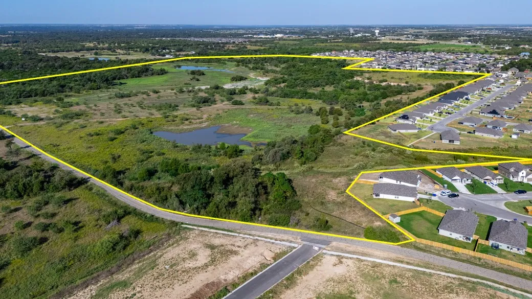 Aerial perspective of suburban area featuring a nearby body of water and property parcel outlined