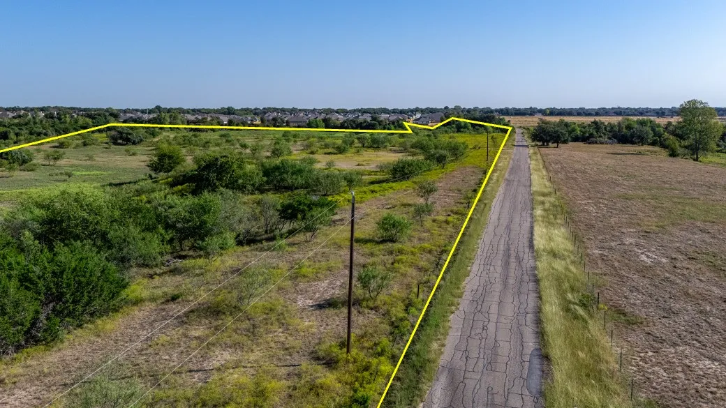 Aerial view of sparsely populated area with property parcel outlined