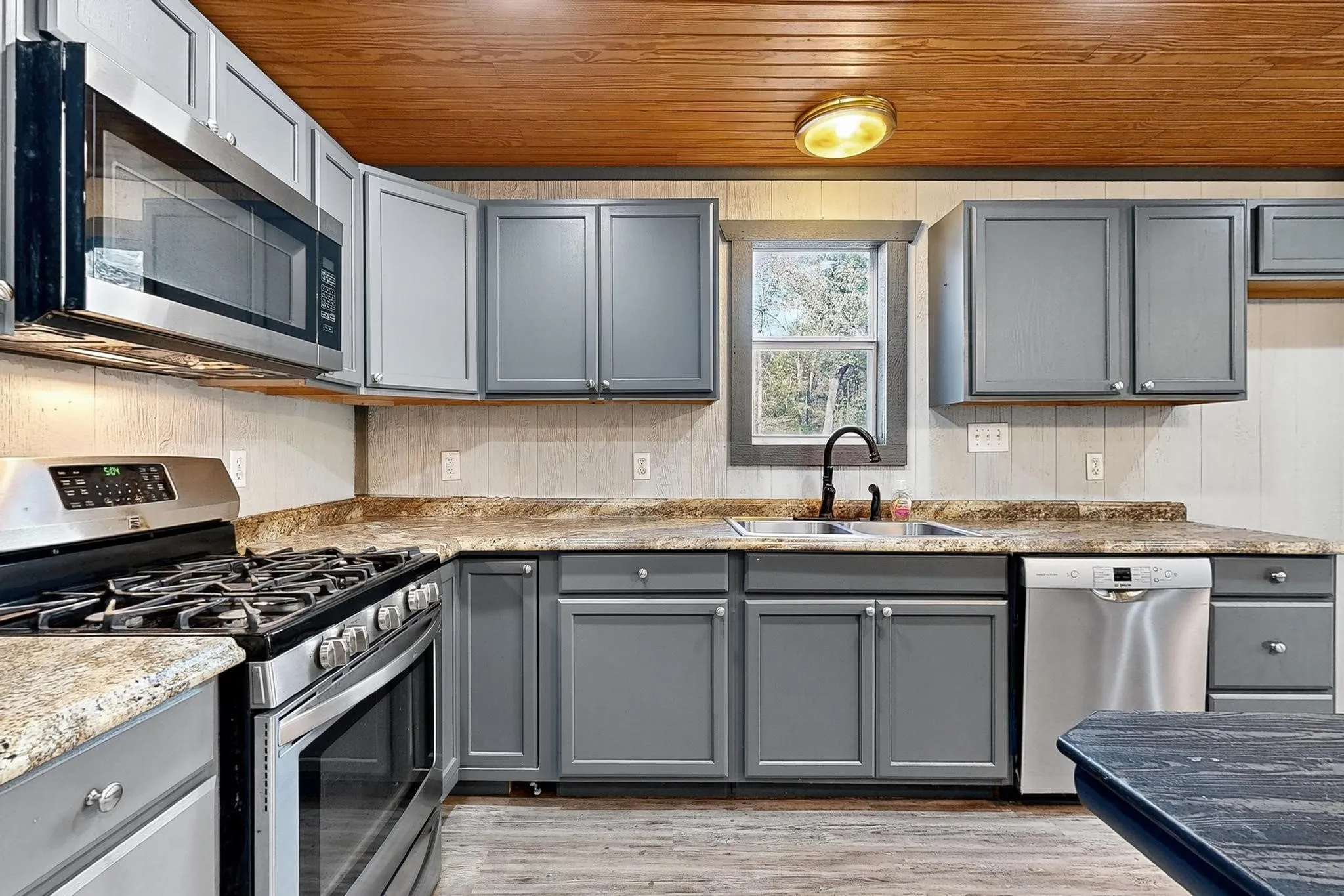 Kitchen featuring gray cabinets, appliances with stainless steel finishes, wood ceiling, light wood-style flooring, and lofted ceiling