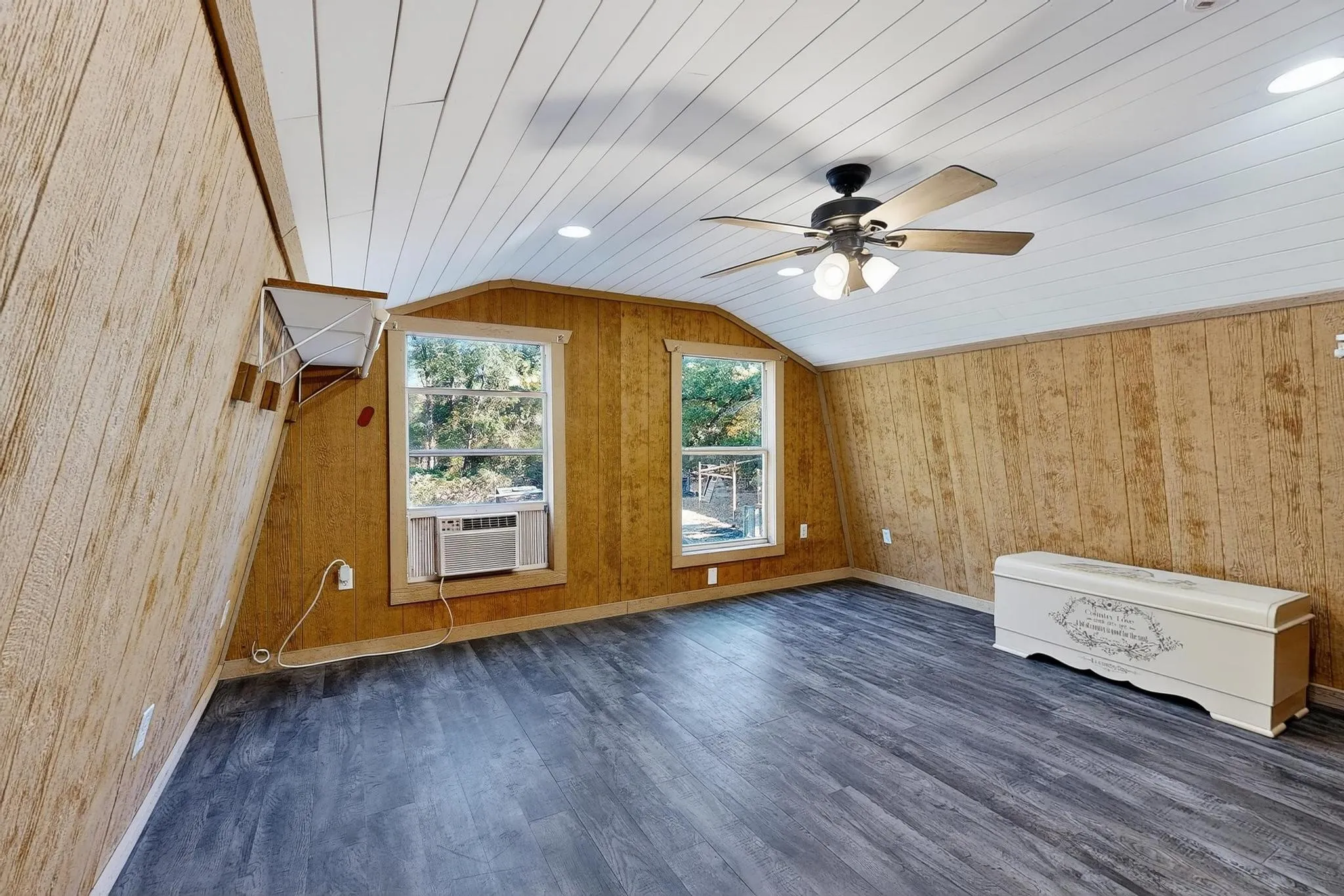Bedroom with dark wood-style floors, vaulted ceiling, wood ceiling, wooden walls, and ceiling fan